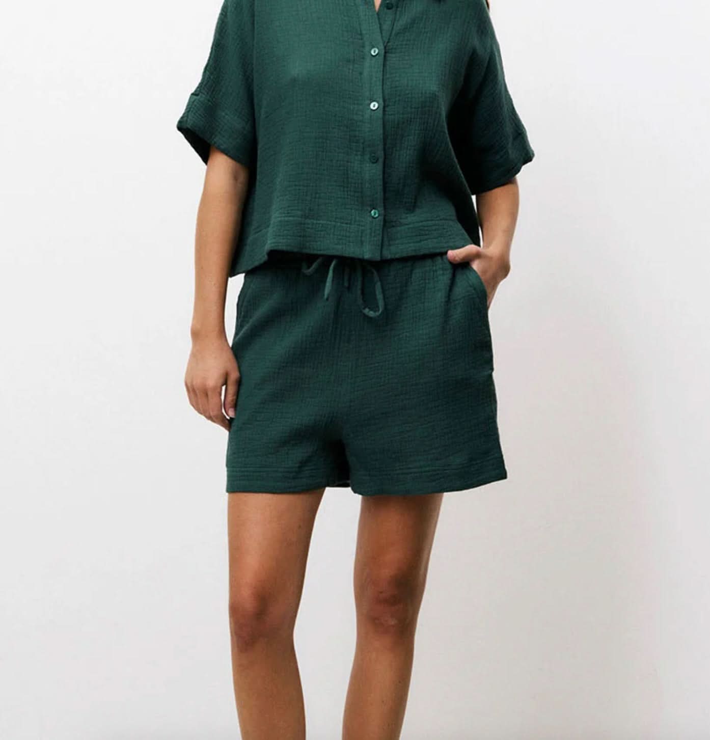 Woman wearing matching dark Forrest green, shorts and short-sleeve set