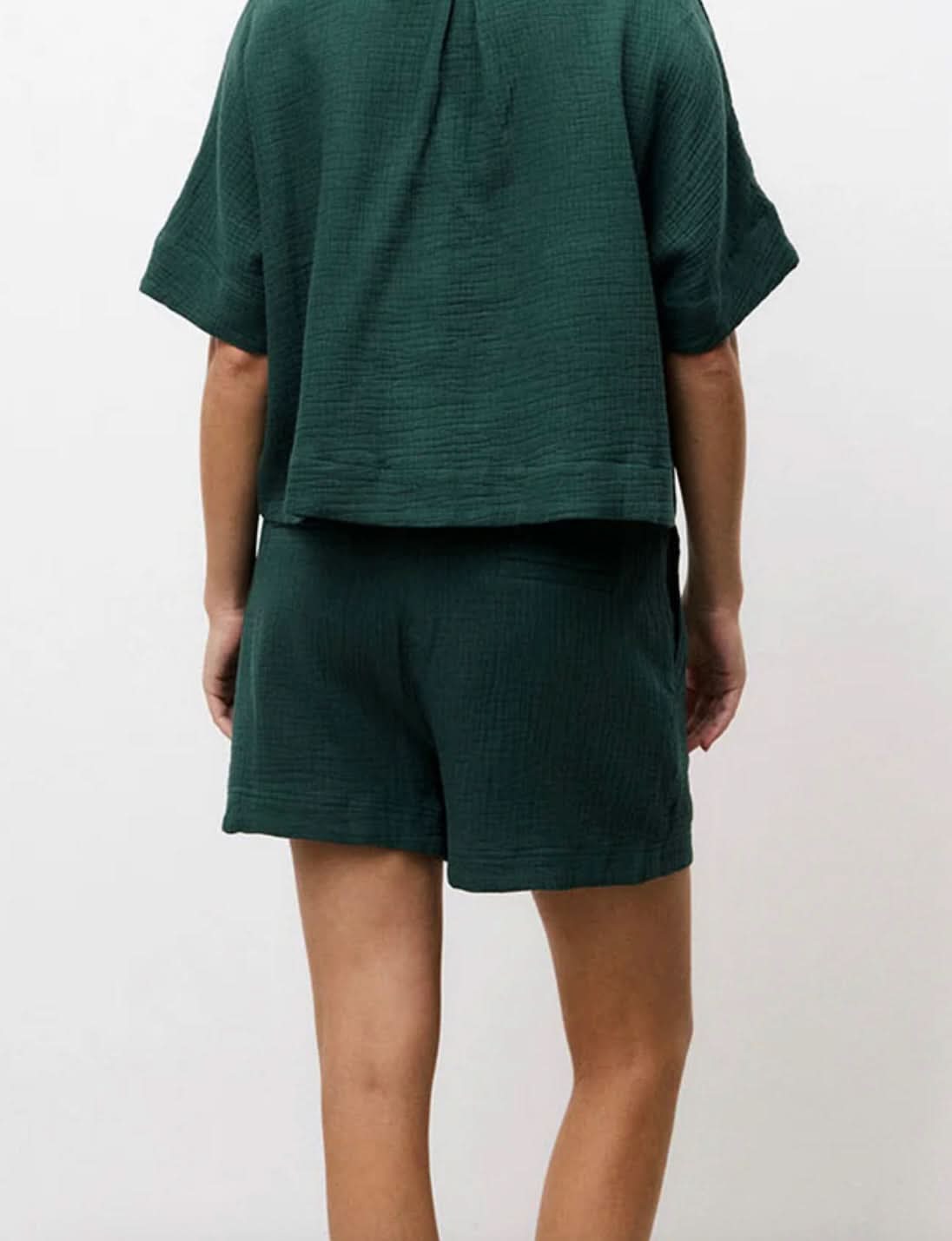 Woman wearing matching dark Forrest green, shorts and short-sleeve set