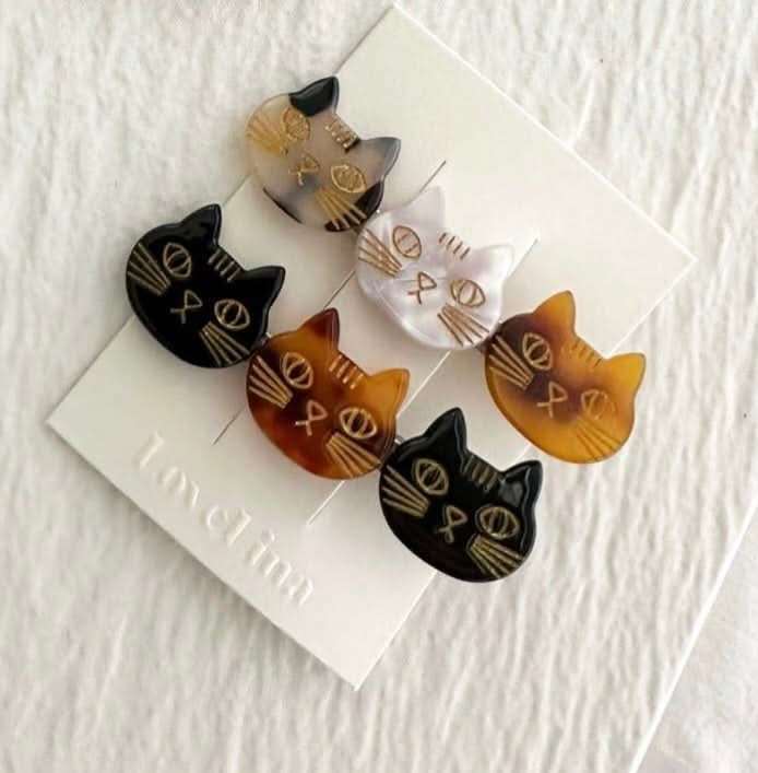 A pair of three colorful cats on a clip in a pack of two behind a white background. 