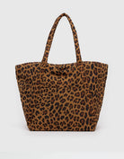 Large leopard tote bag behind a white background. 