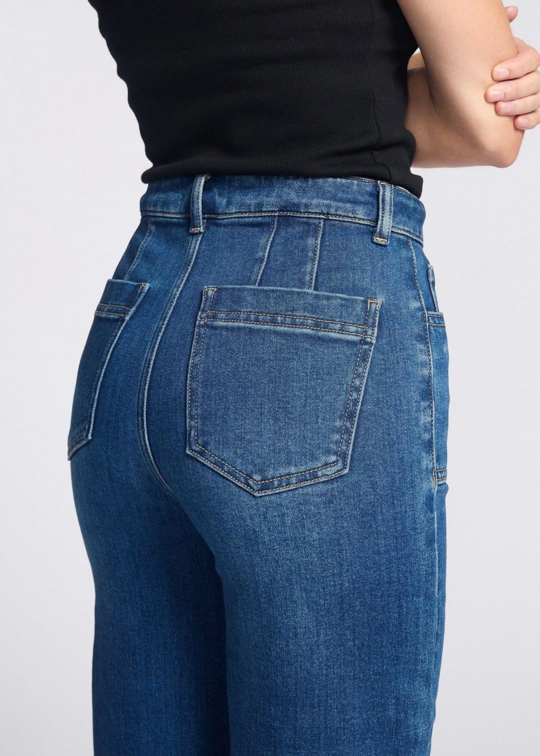 Close-up of blue jeans with a plain background