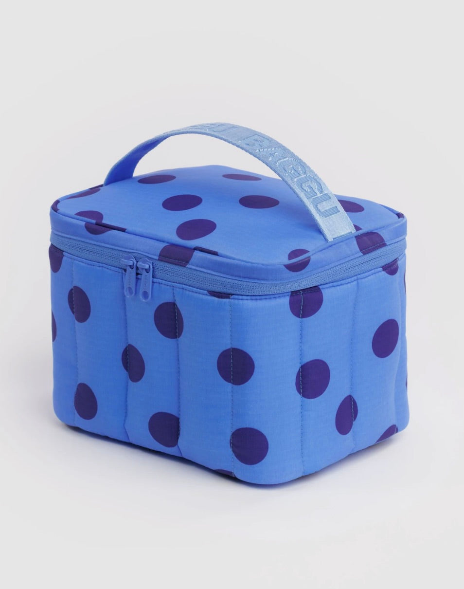 A blue quilted lunch bag with dark purple polka dots and a light blue top handle featuring the brand name 'RAGGU' in white.
