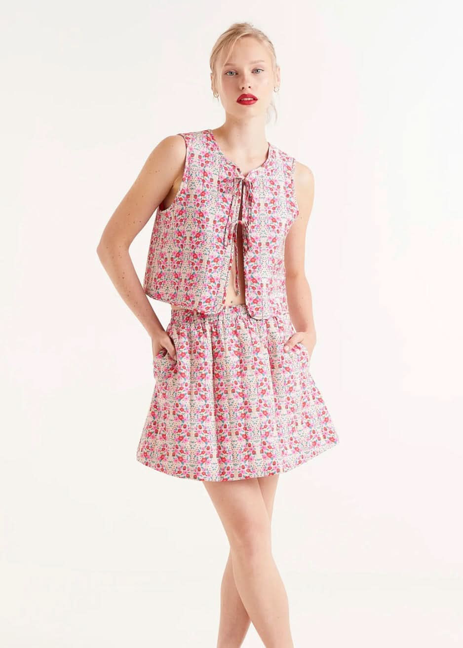 Woman wearing strawberry and floral collared ruffle sleeve button up skirt and matching top