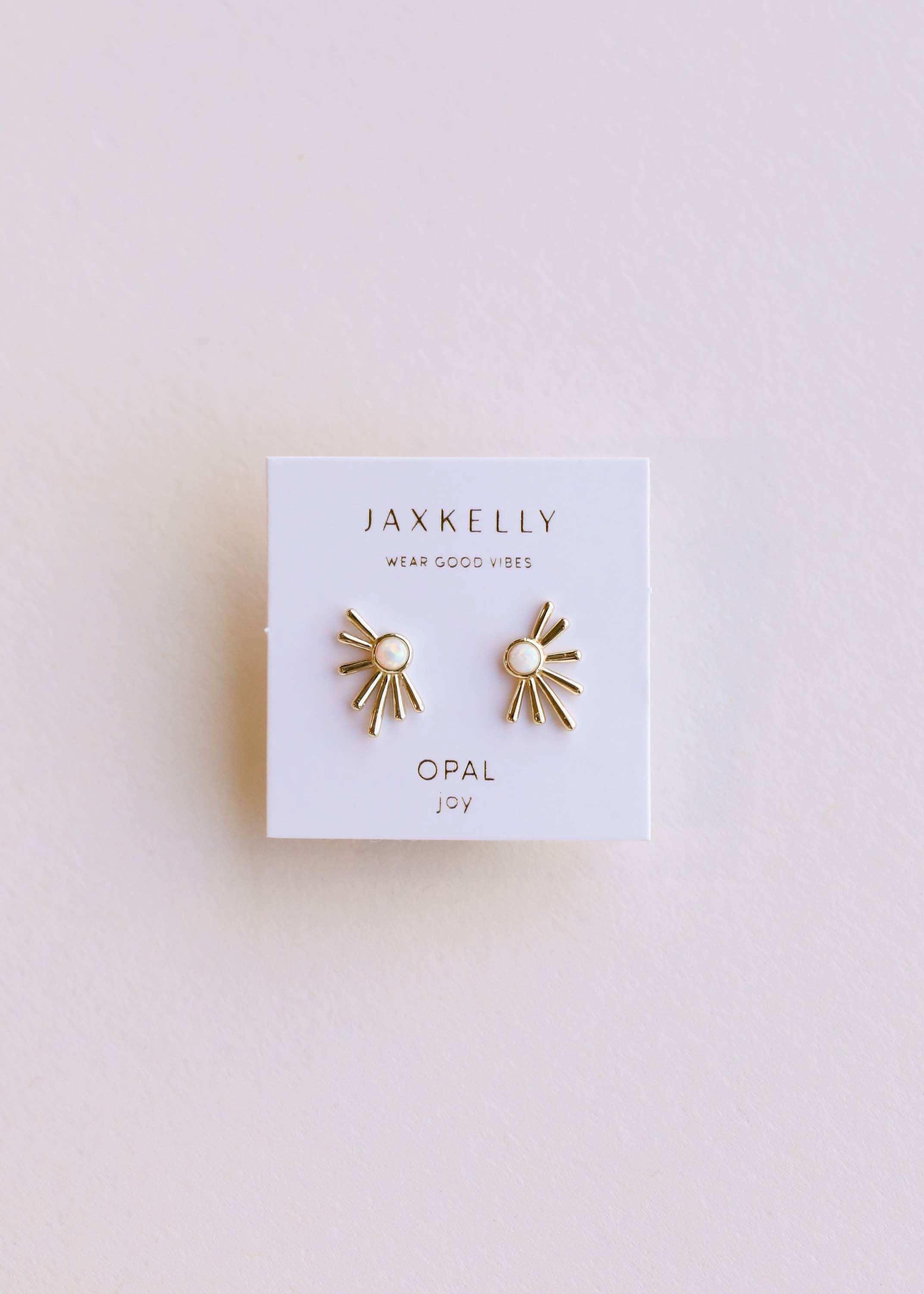 Gold earrings on a Jaxkelly branded card against a light background