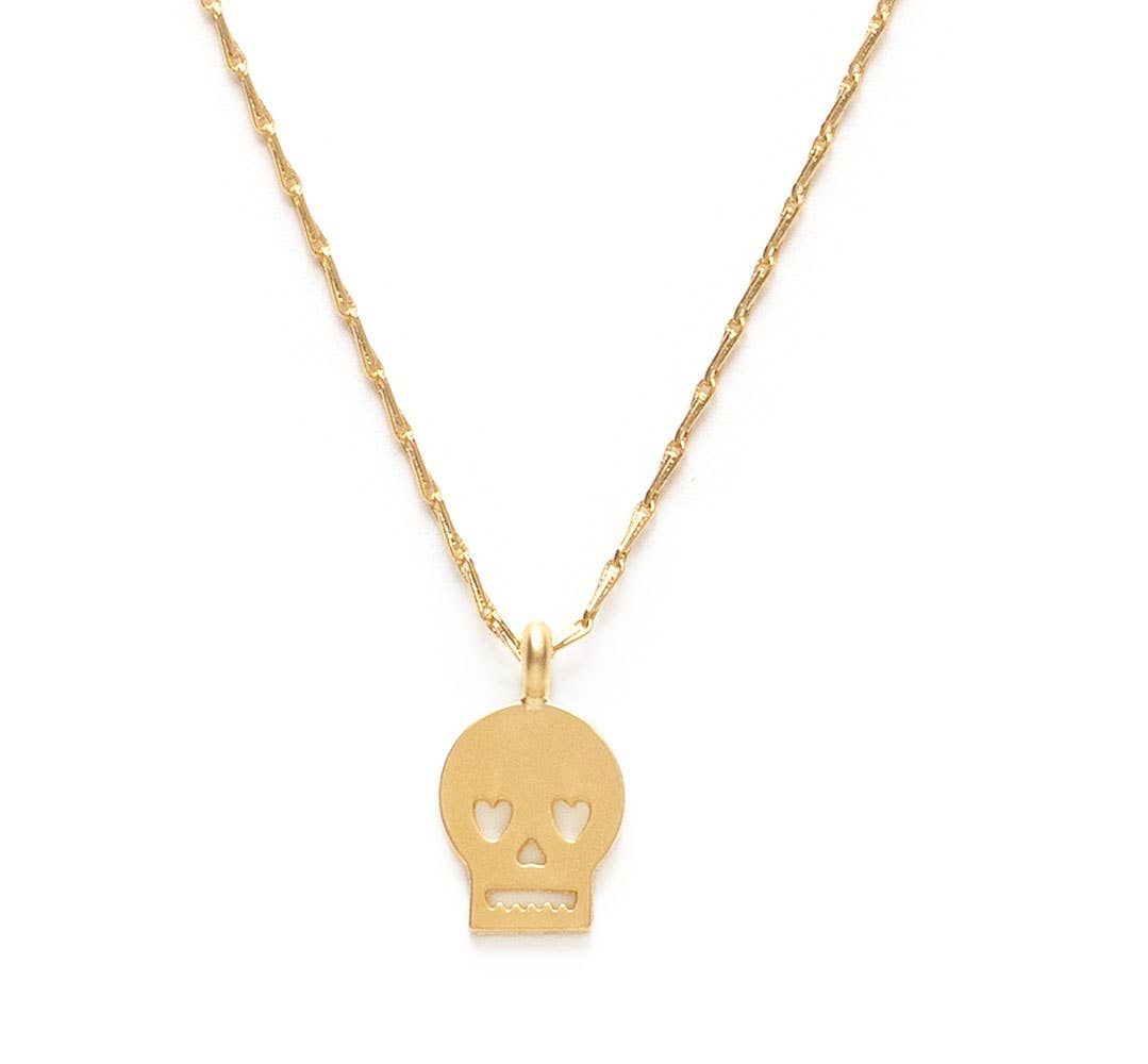 Gold skull pendant necklace on a white background