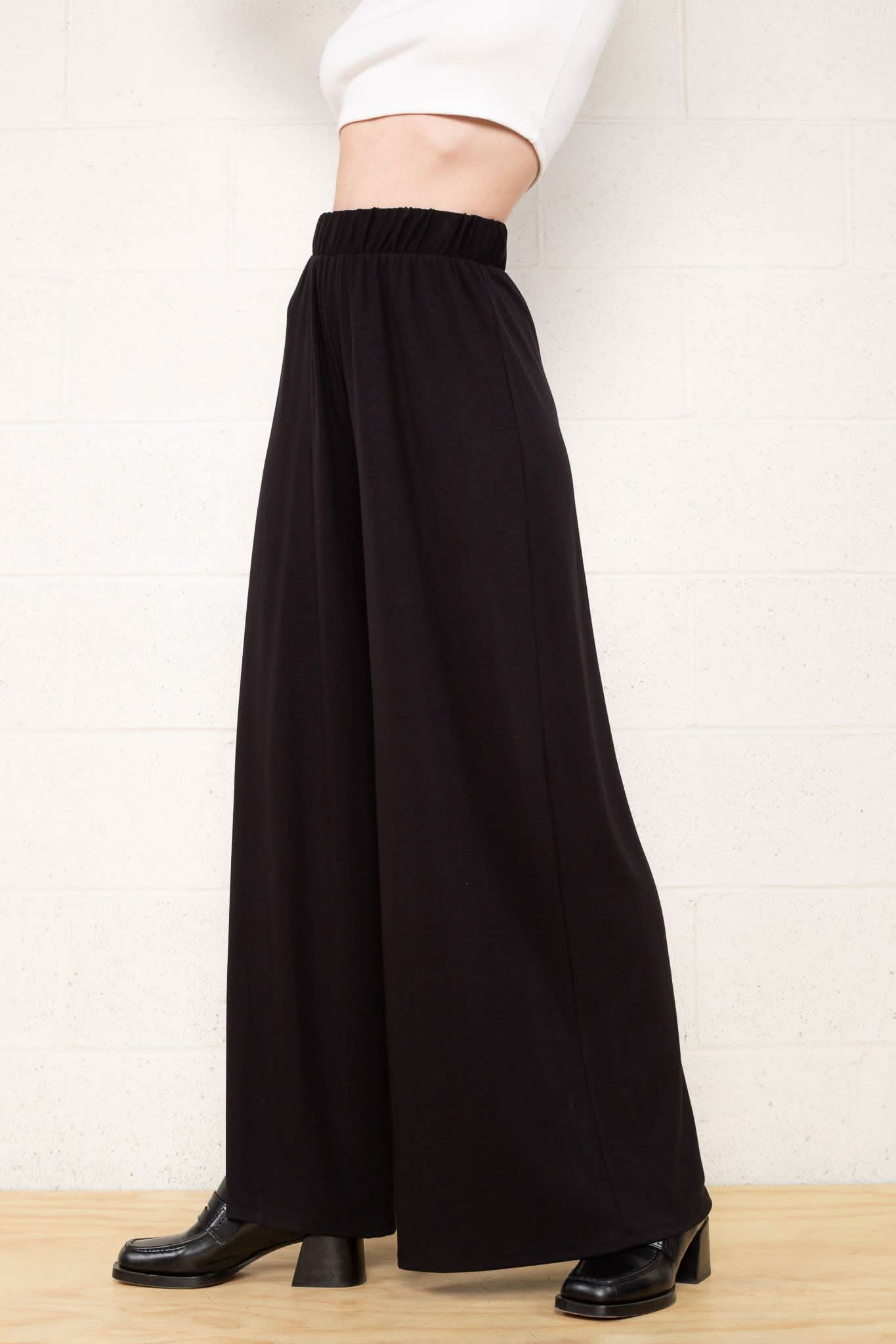 Person wearing black wide-leg pants Made from high-quality materials and designed with a comfortable elastic waist