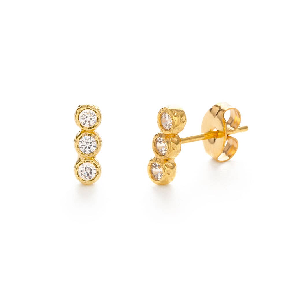 Gold earrings with clear gemstones on a white background
