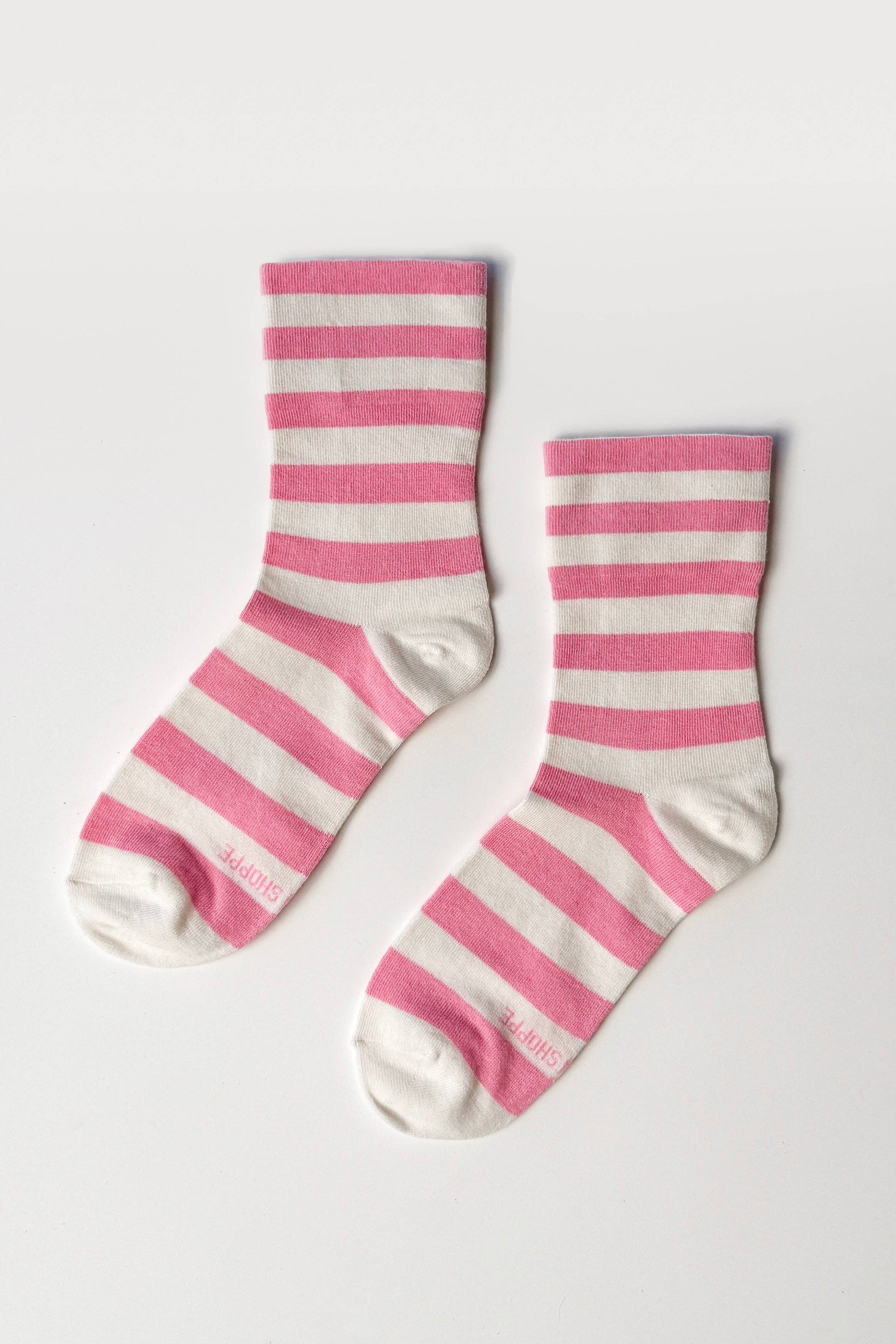 Pair of pink and white striped socks on a light gray background