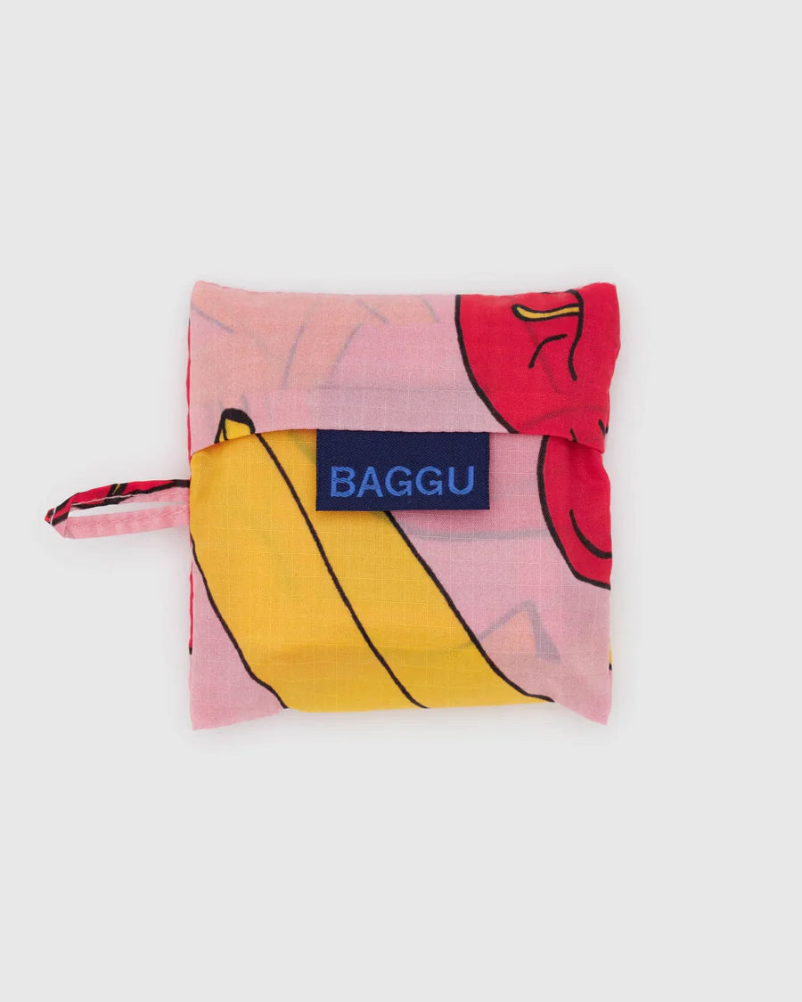 White background and BAGGU light pink reuse-able bag with apples and banana details, folded 