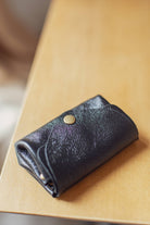 Small black Metal leather wallet with over flap and gold button clasp 