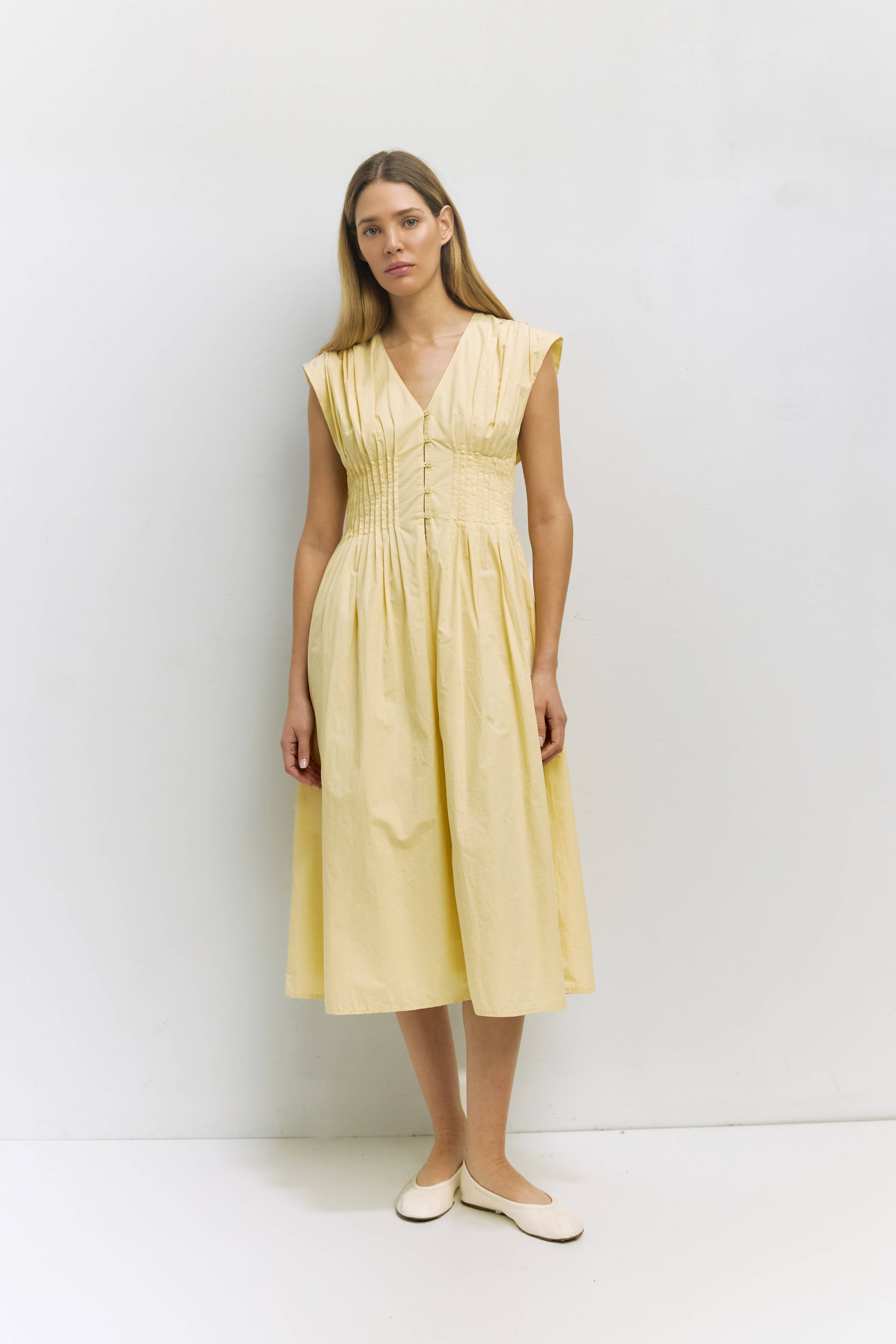 Woman wearing a yellow dress against a white background