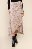 Woman wearing beige, ruffle, floral print, wrap skirt and black top 