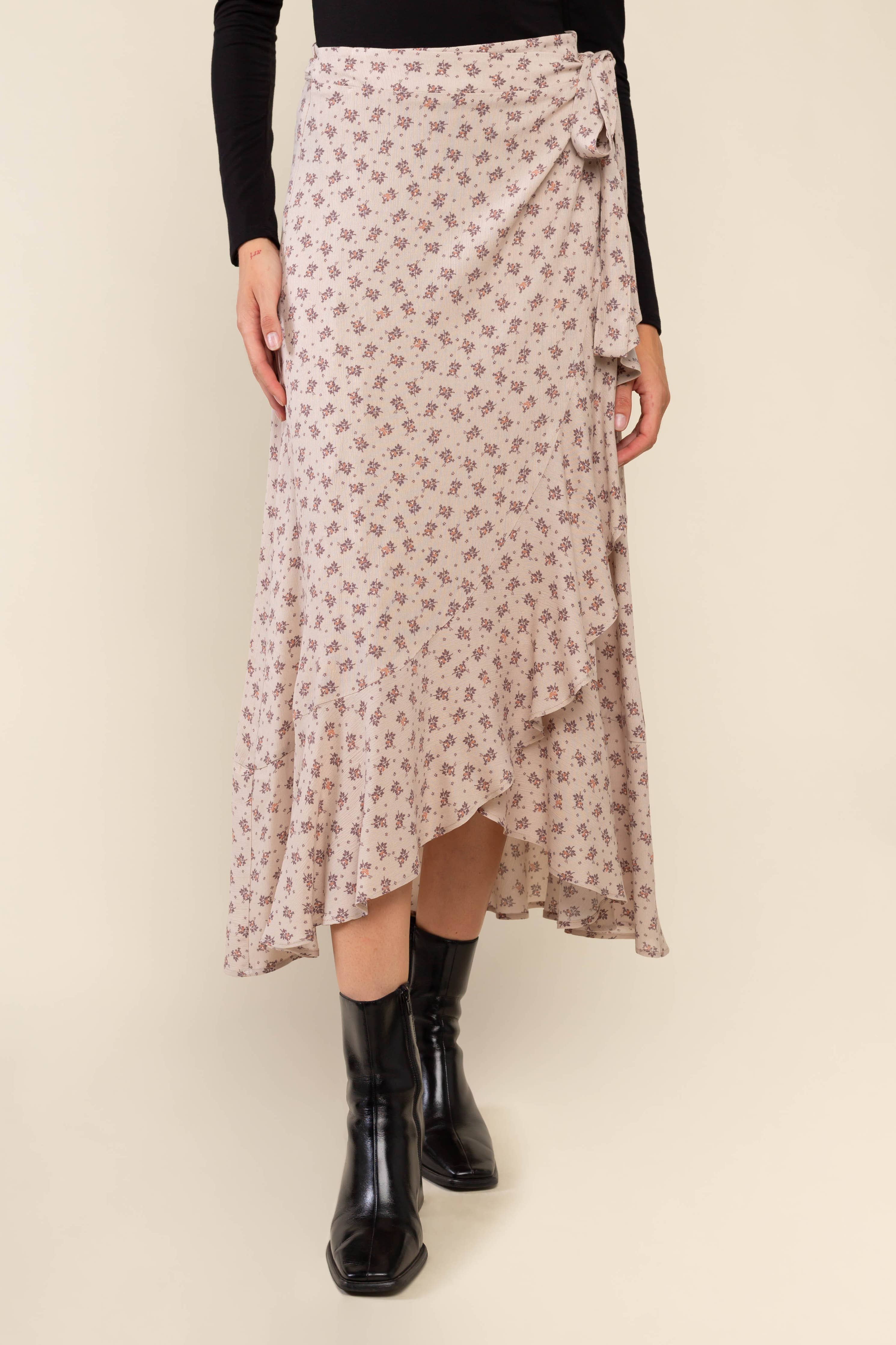 Woman wearing beige, ruffle, floral print, wrap skirt and black top 