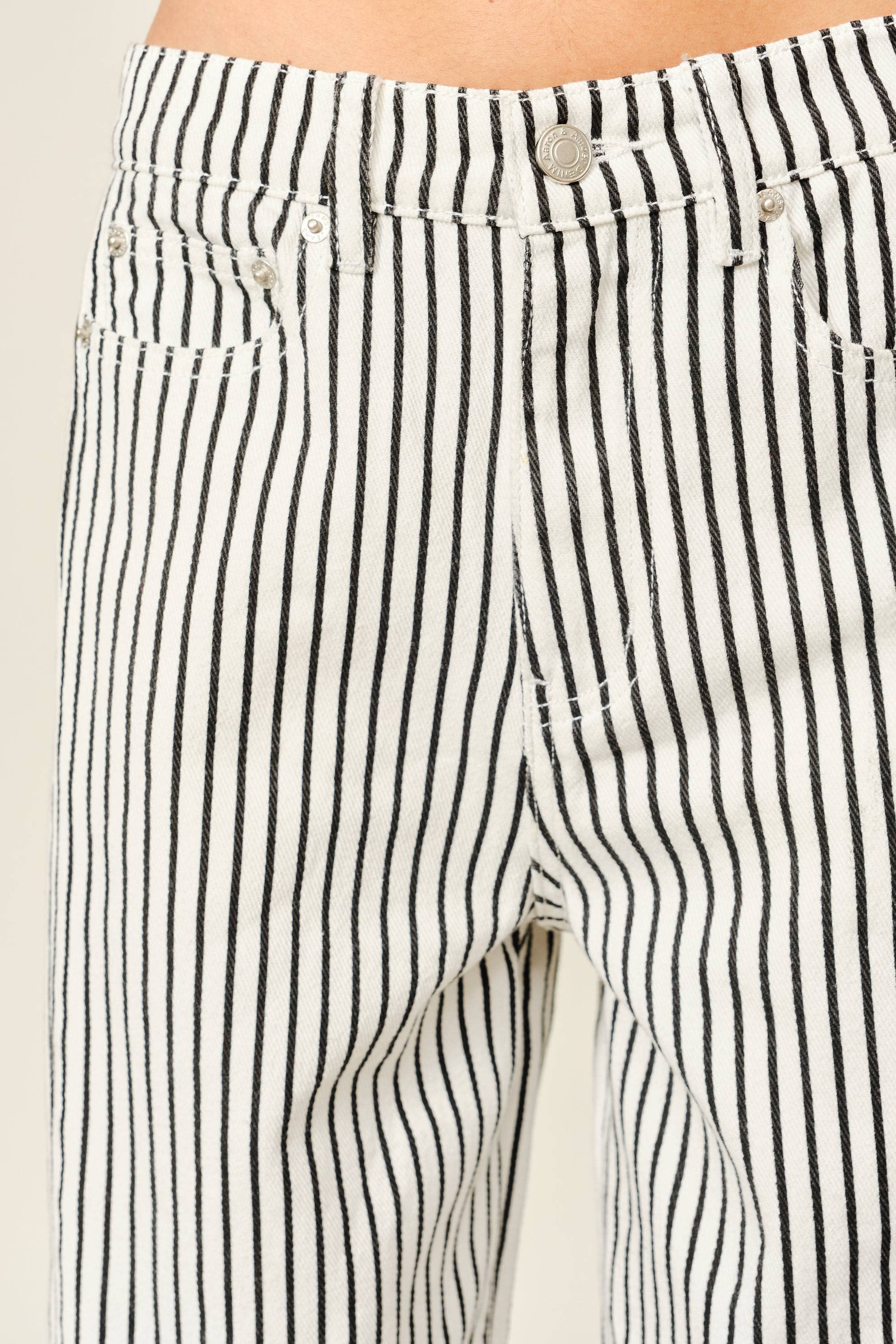 Close-up of black and white striped pants with a beige background