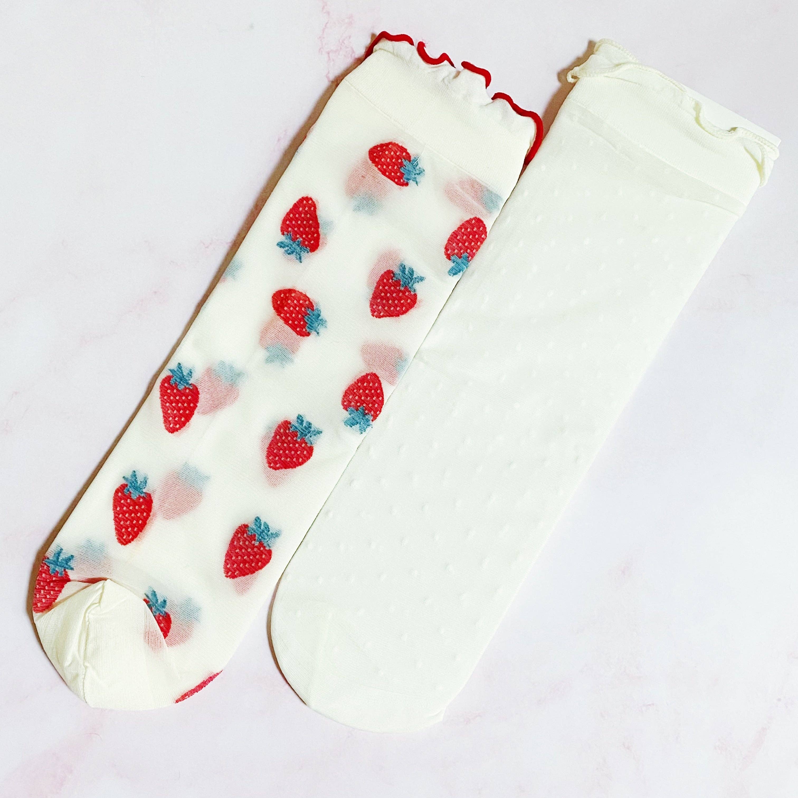 White knee-high socks with strawberry pattern on a white background