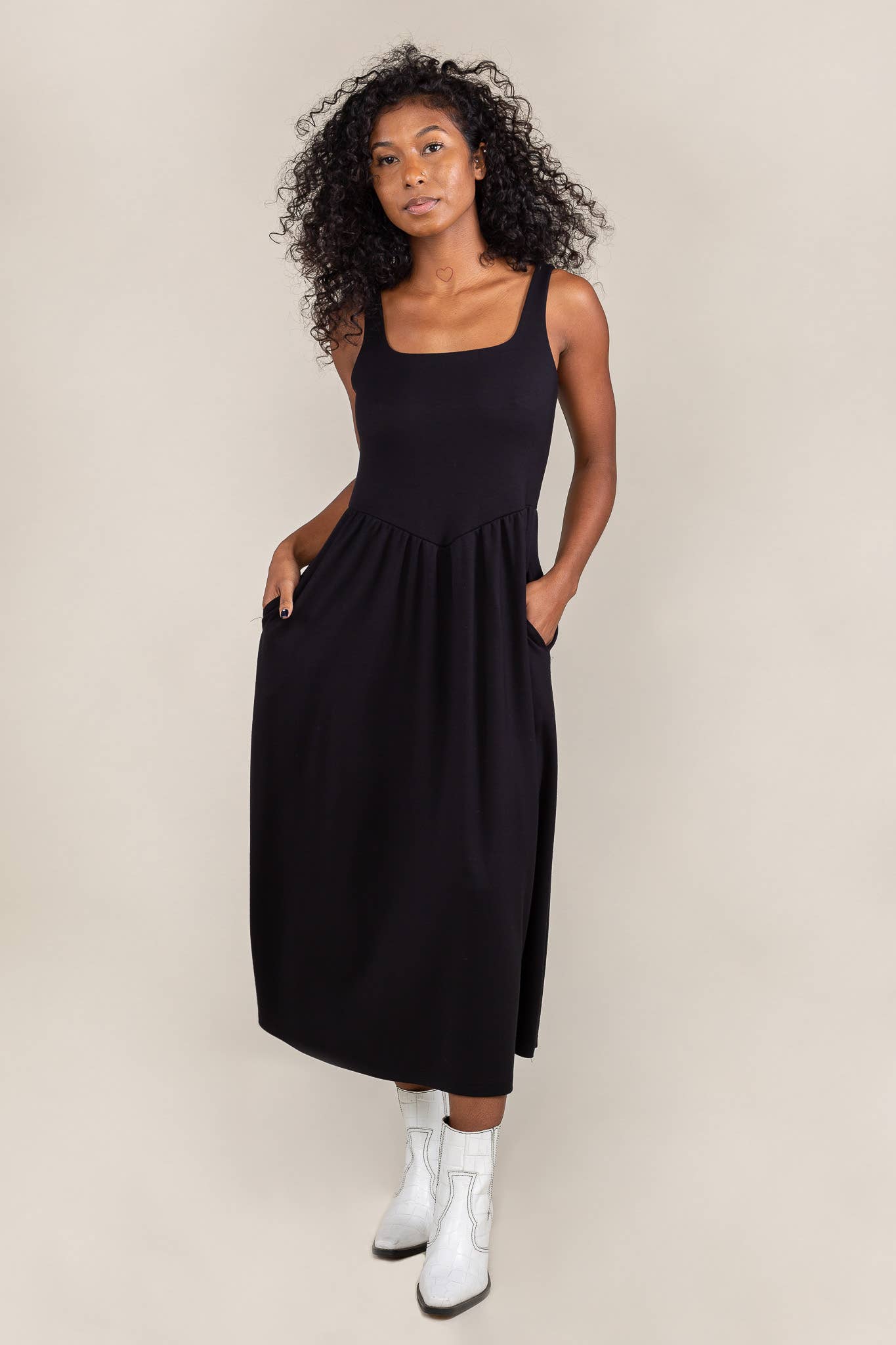 Woman wearing black colored, midi dress, with corset bodice detail