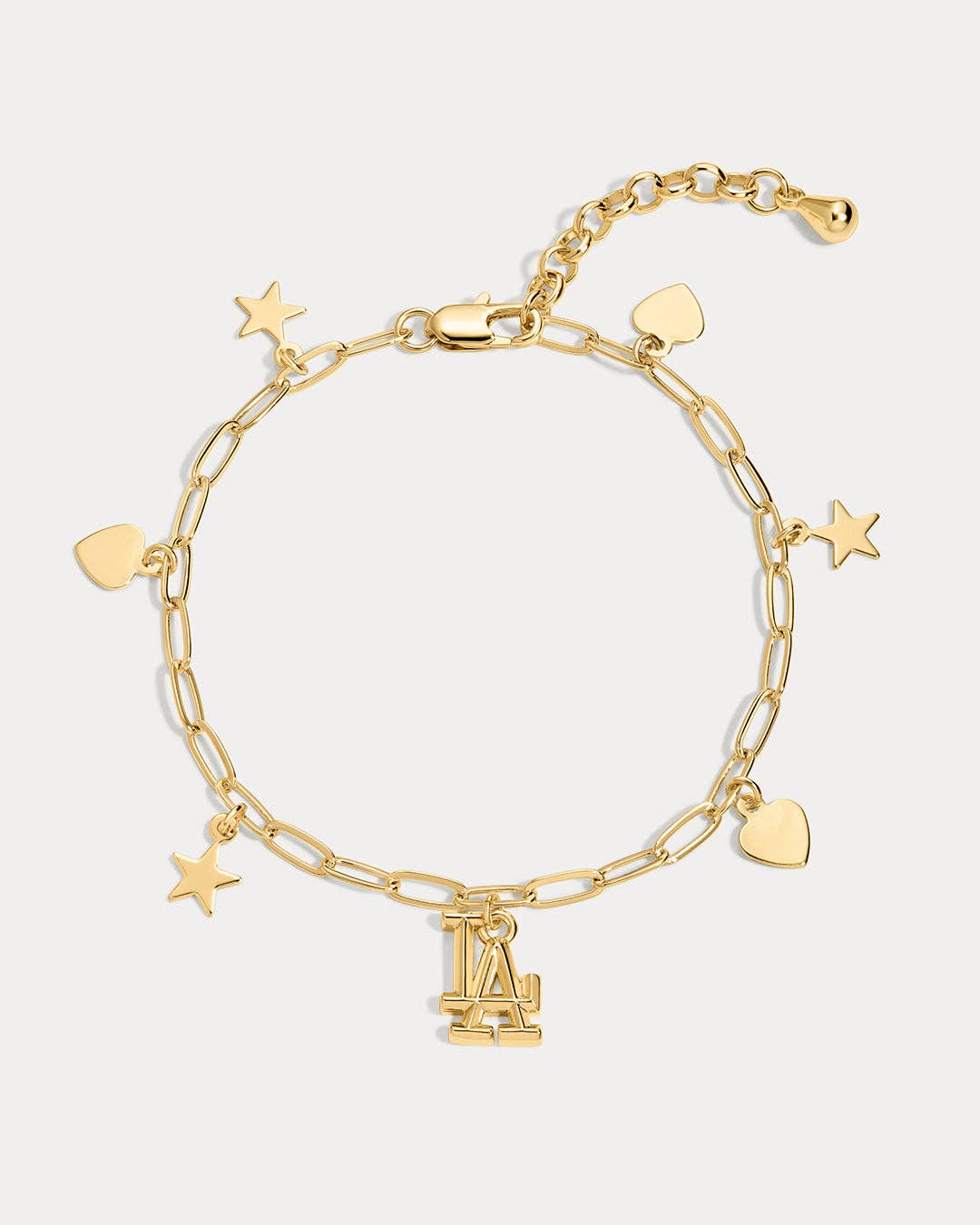 A gold chain bracelet featuring paperclip links, heart charms, star charms, and a central interlocking LA logo charm, displayed on a light gray background.