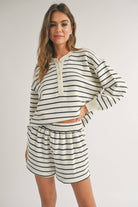 woman wearing black and white striped, half button cozy warm and stylish design