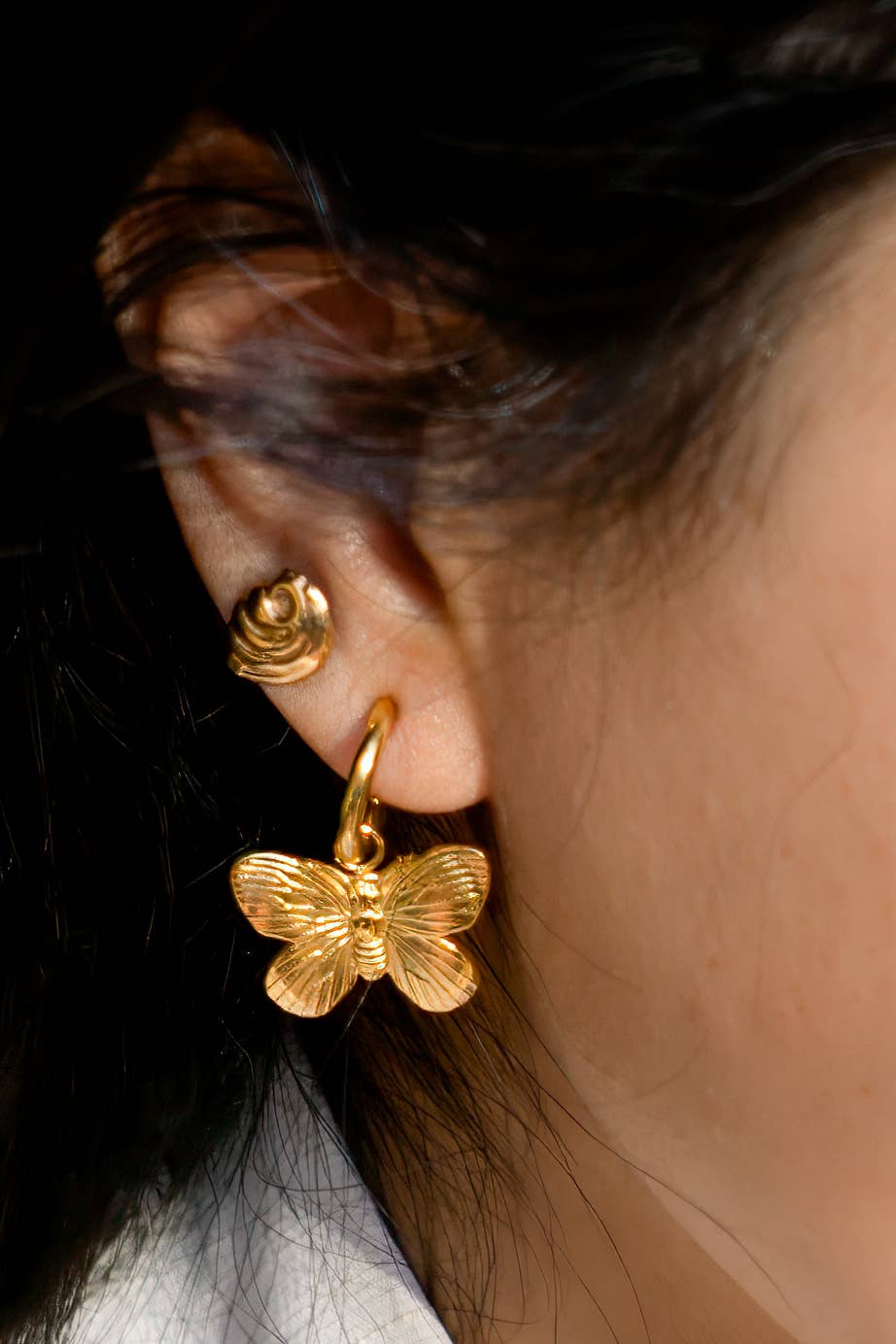 Woman wearing Gold butterfly hoop earring