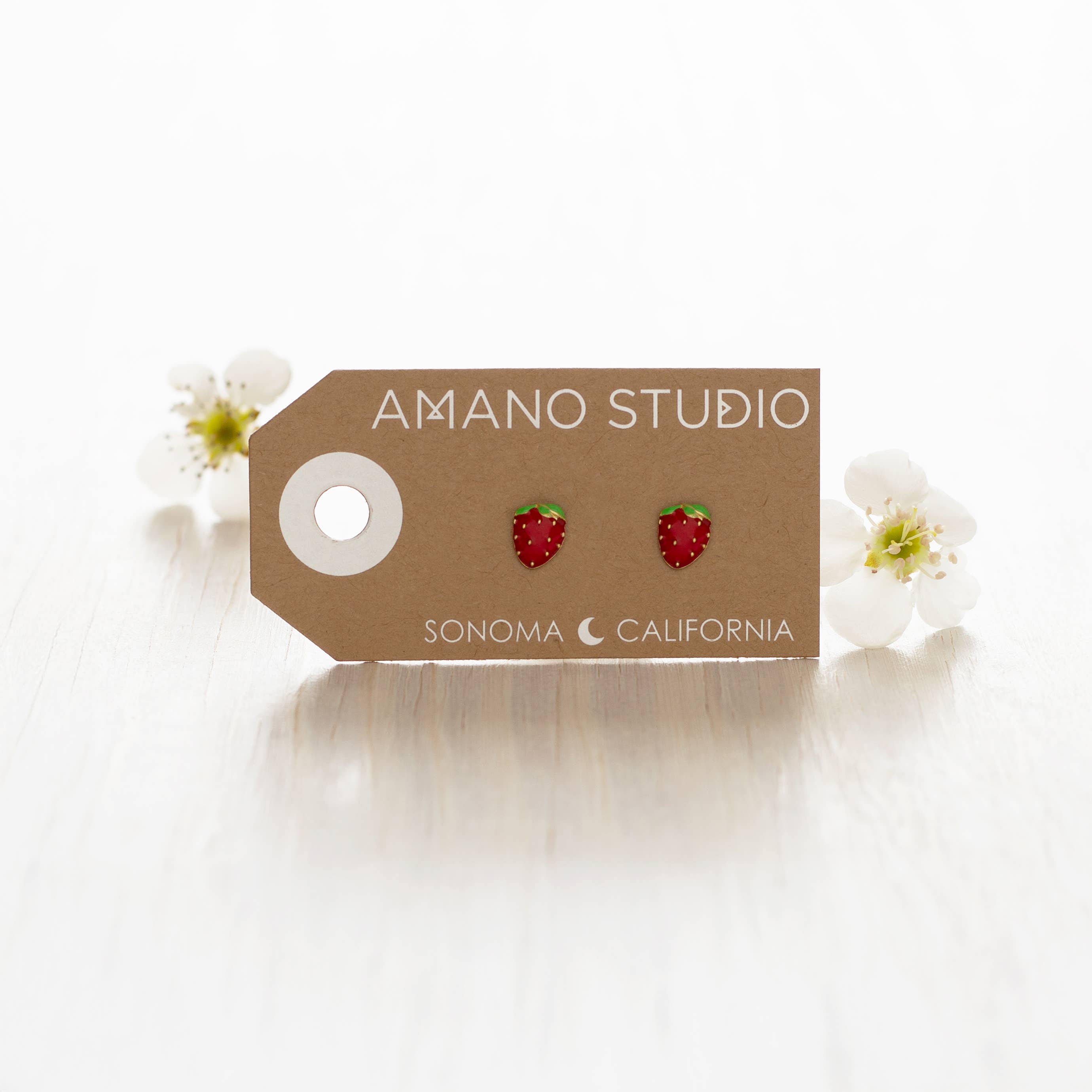 Strawberry stud earrings shown on display card 