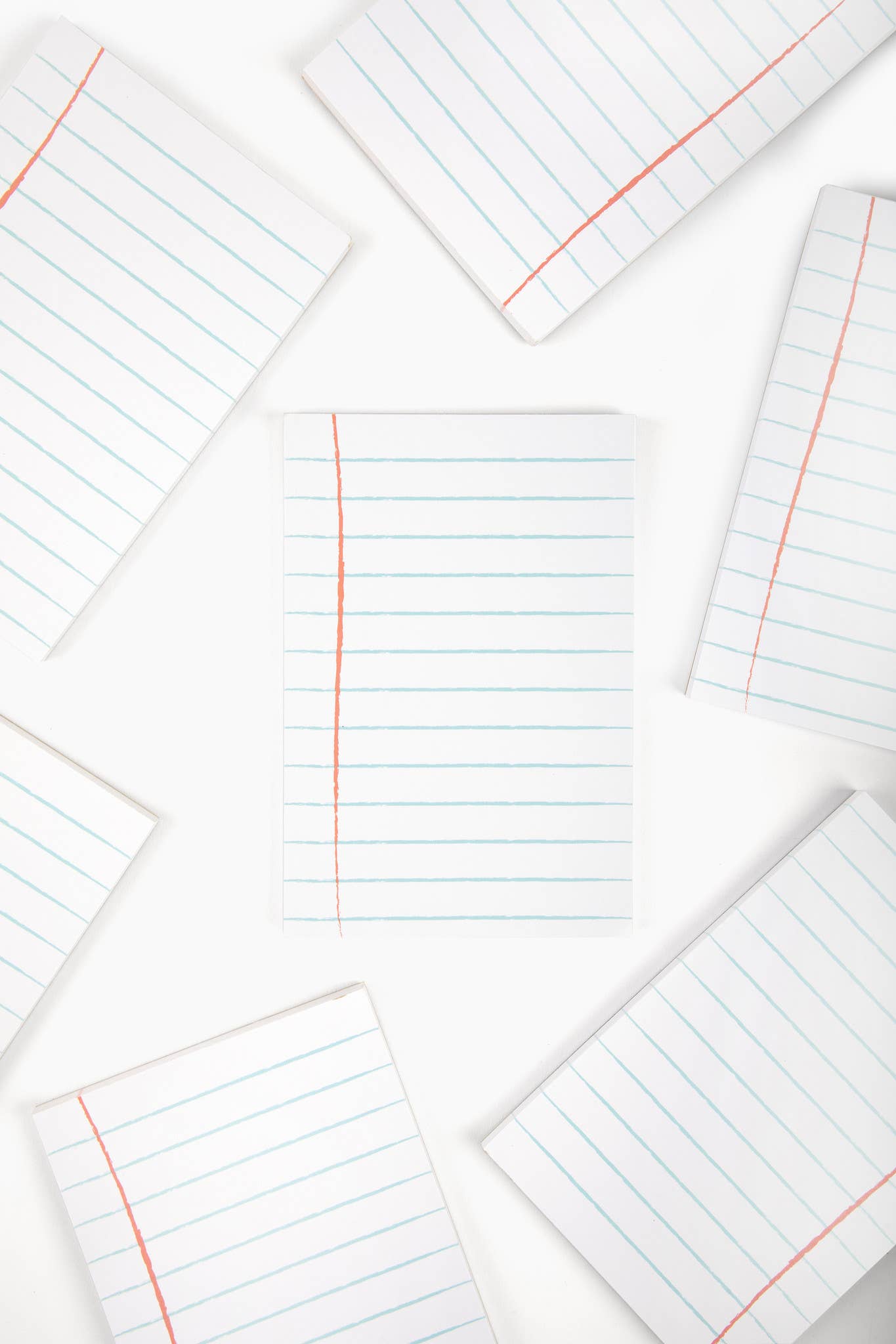 Multiple sheets of lined paper with red and blue lines on a white background