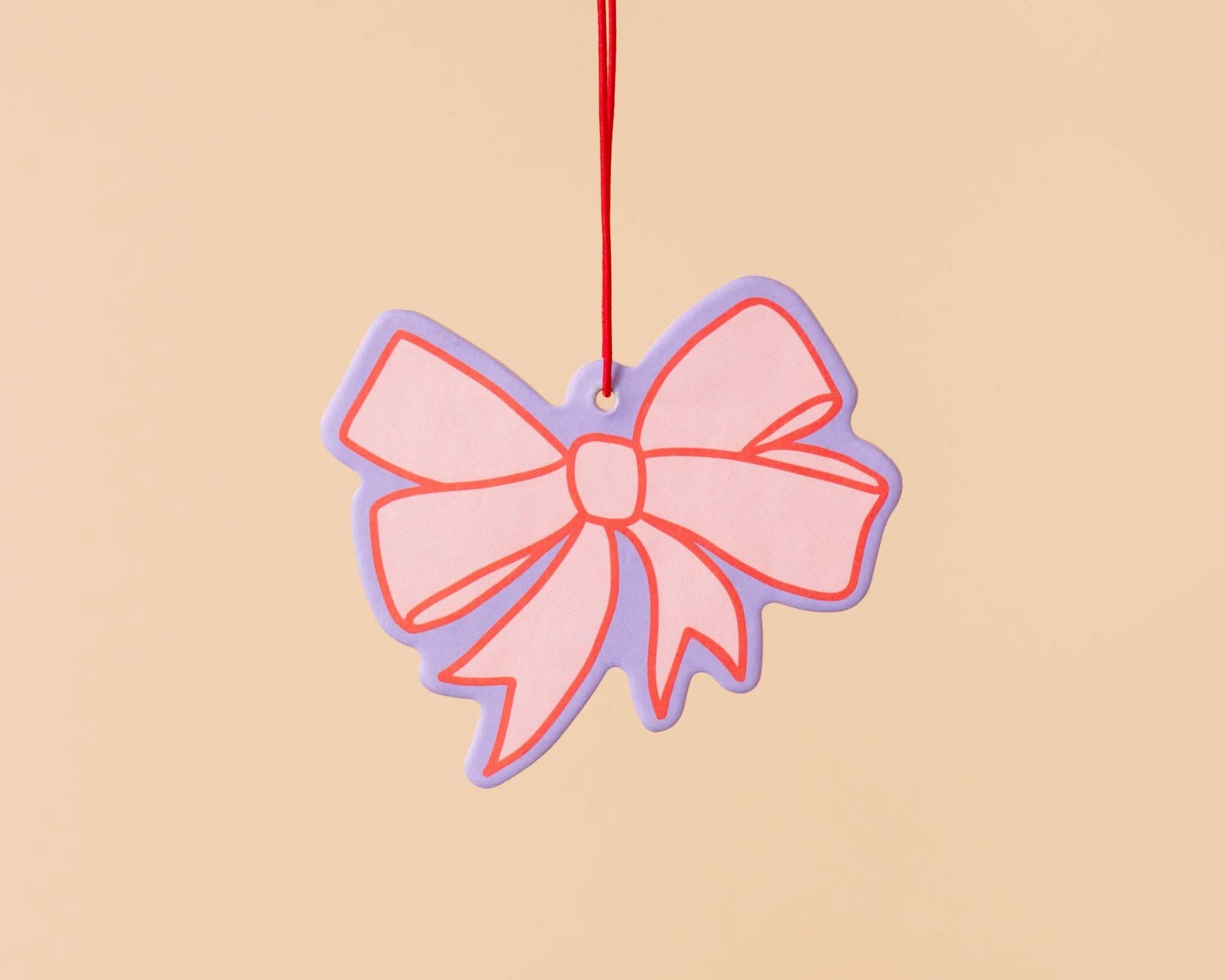 pink car air freshener with lavender and red detail