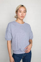 Woman wearing natural grey, short sleeve, puff sleeve, blouse t-shirt top 