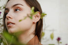 woman wearing white, pave, square cut silver hoop earrings