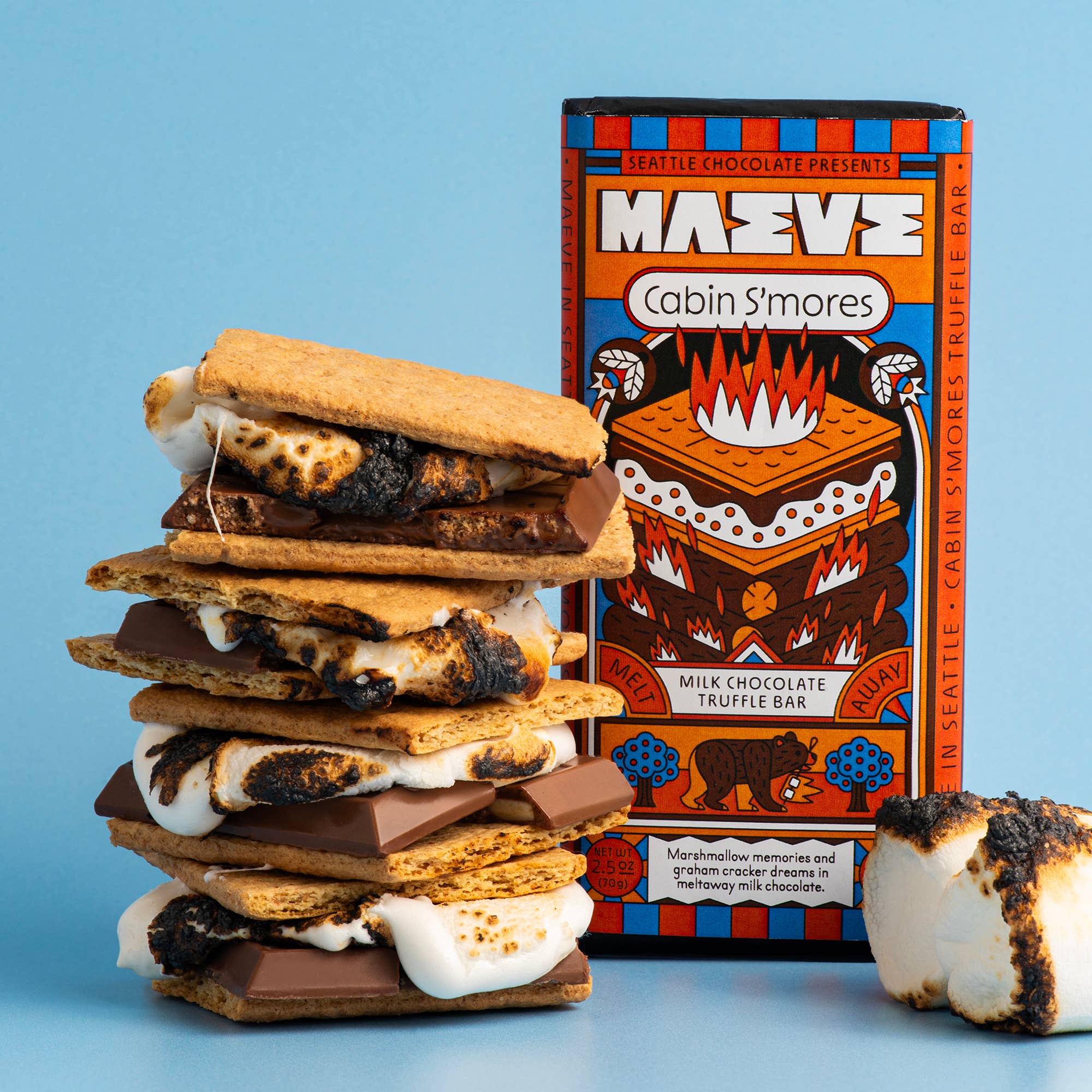 Stack of s'mores with a box of Maeve Cabin S'mores on a blue background
