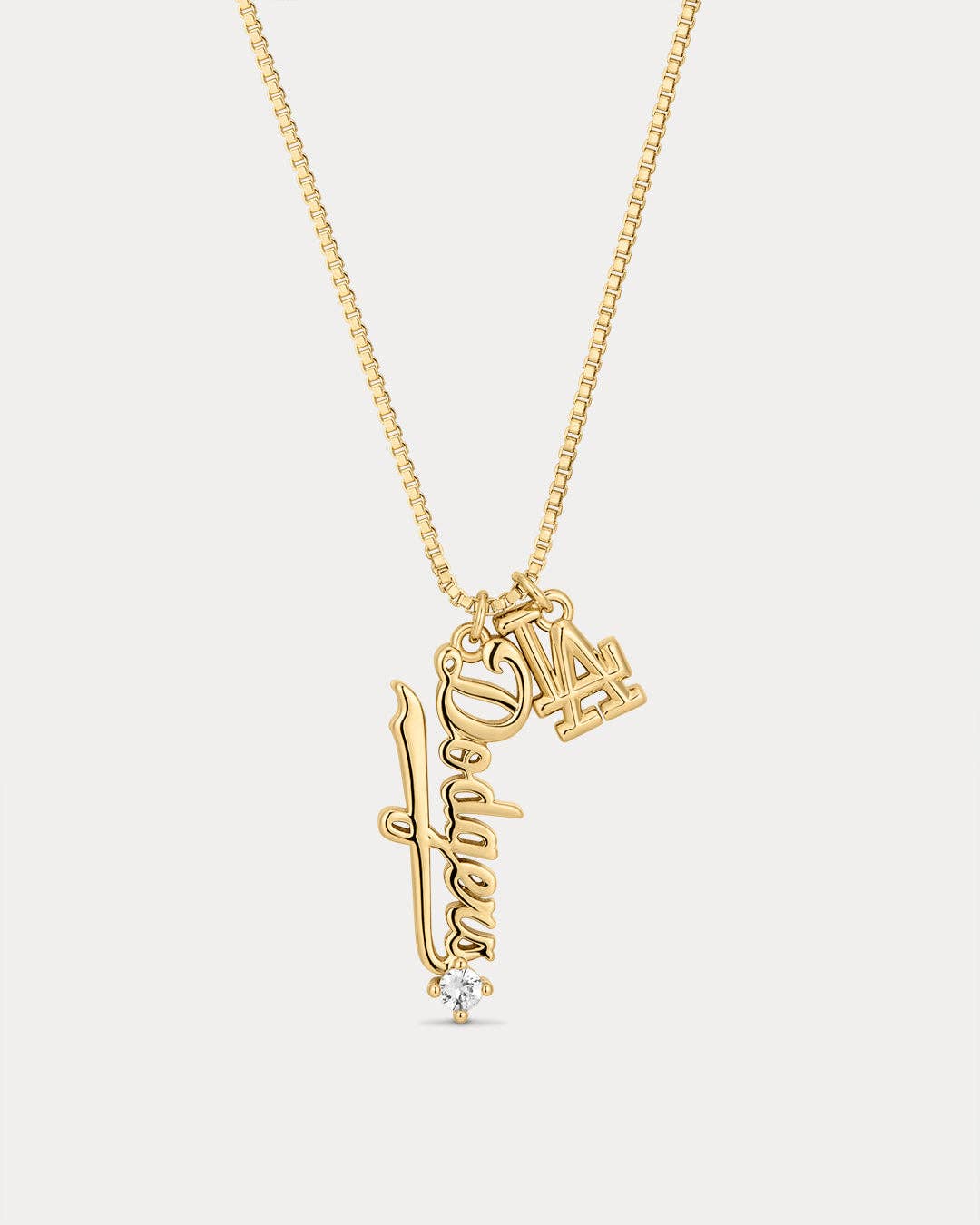 Gold necklace with two pendants on a white background