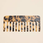 Light brown tortoise comb laying flat on white background 