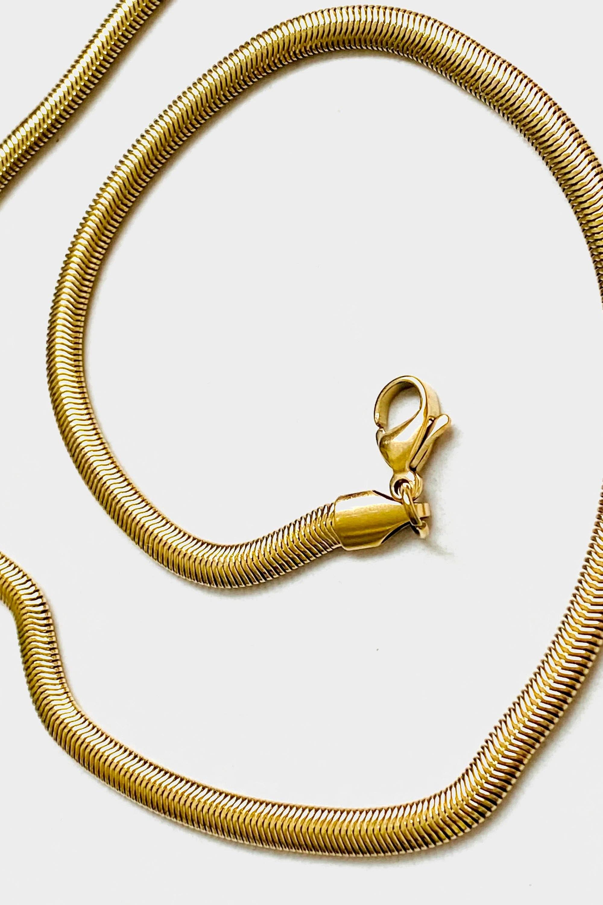 Close up on lobster clasp of 18k gold 15 inch to 17 inch herringbone necklace laid out in a swirl pattern on white background 