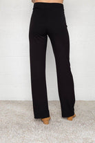 Woman wearing flats and black Micah pants that are skinny on the top with wide bottom