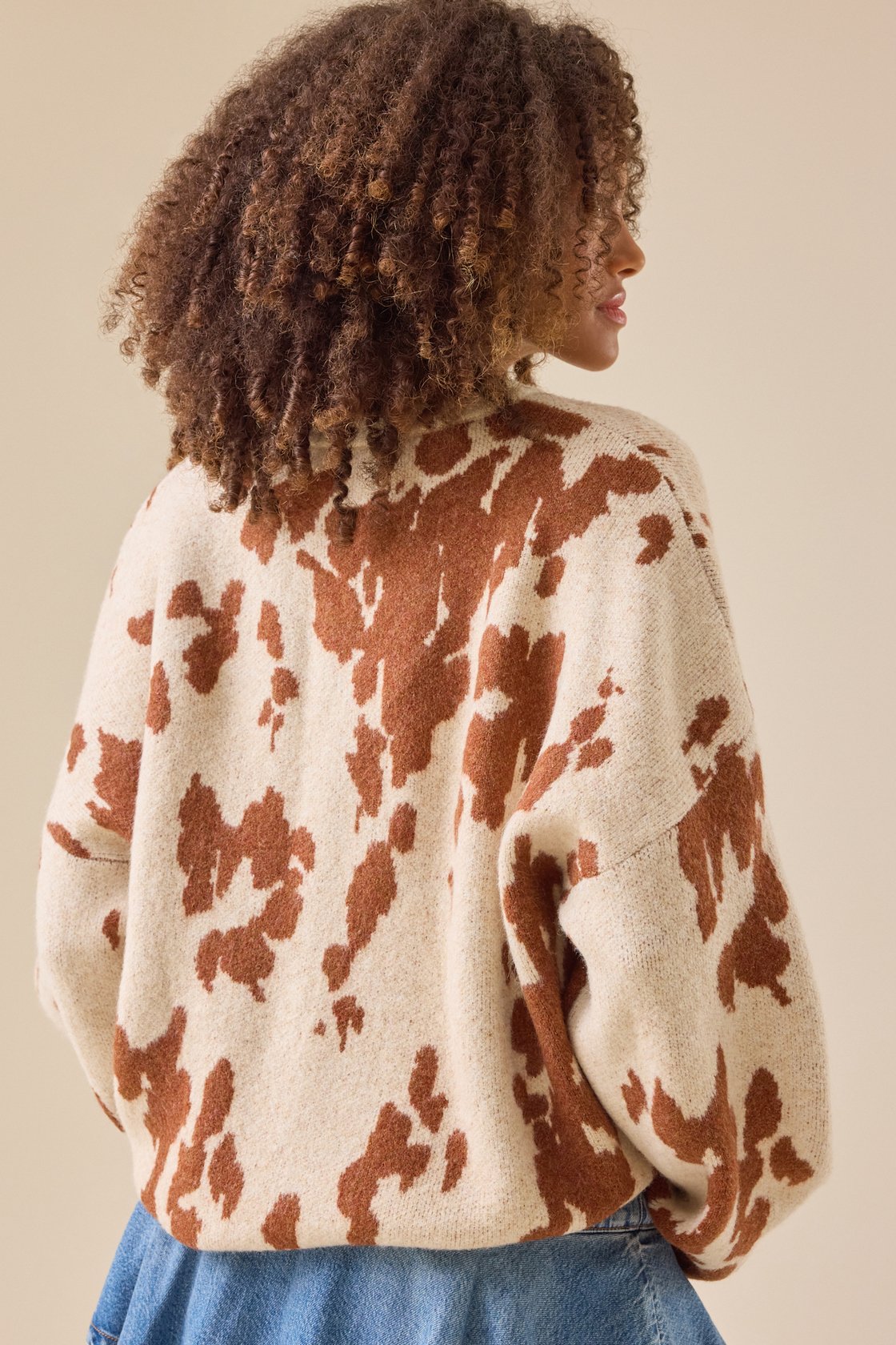 This statement knit features a bold cow print design that is sure to turn heads.