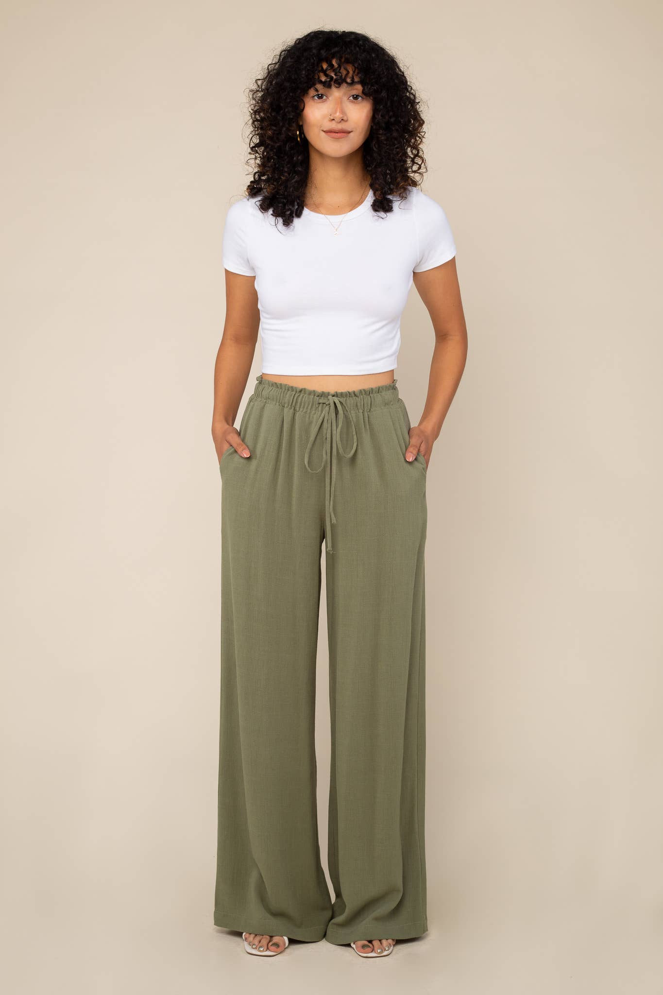 Woman wearing Sage green, wide leg, cove linen pant and white tee 
