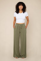 Woman wearing Sage green, wide leg, cove linen pant and white tee 