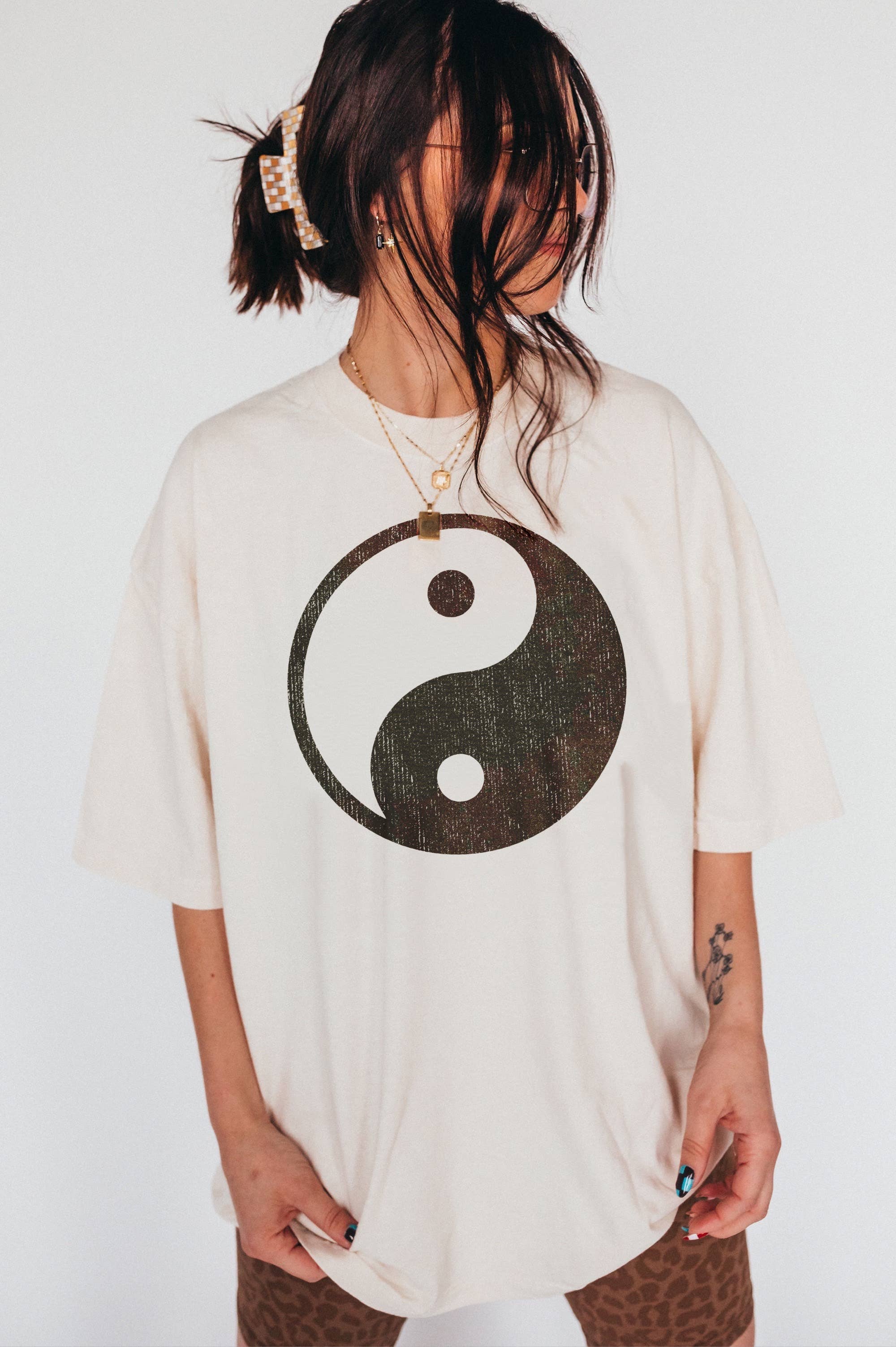 woman wearing hand printed, entirely cotton t-shirt with distressed boho Yin-yang design 