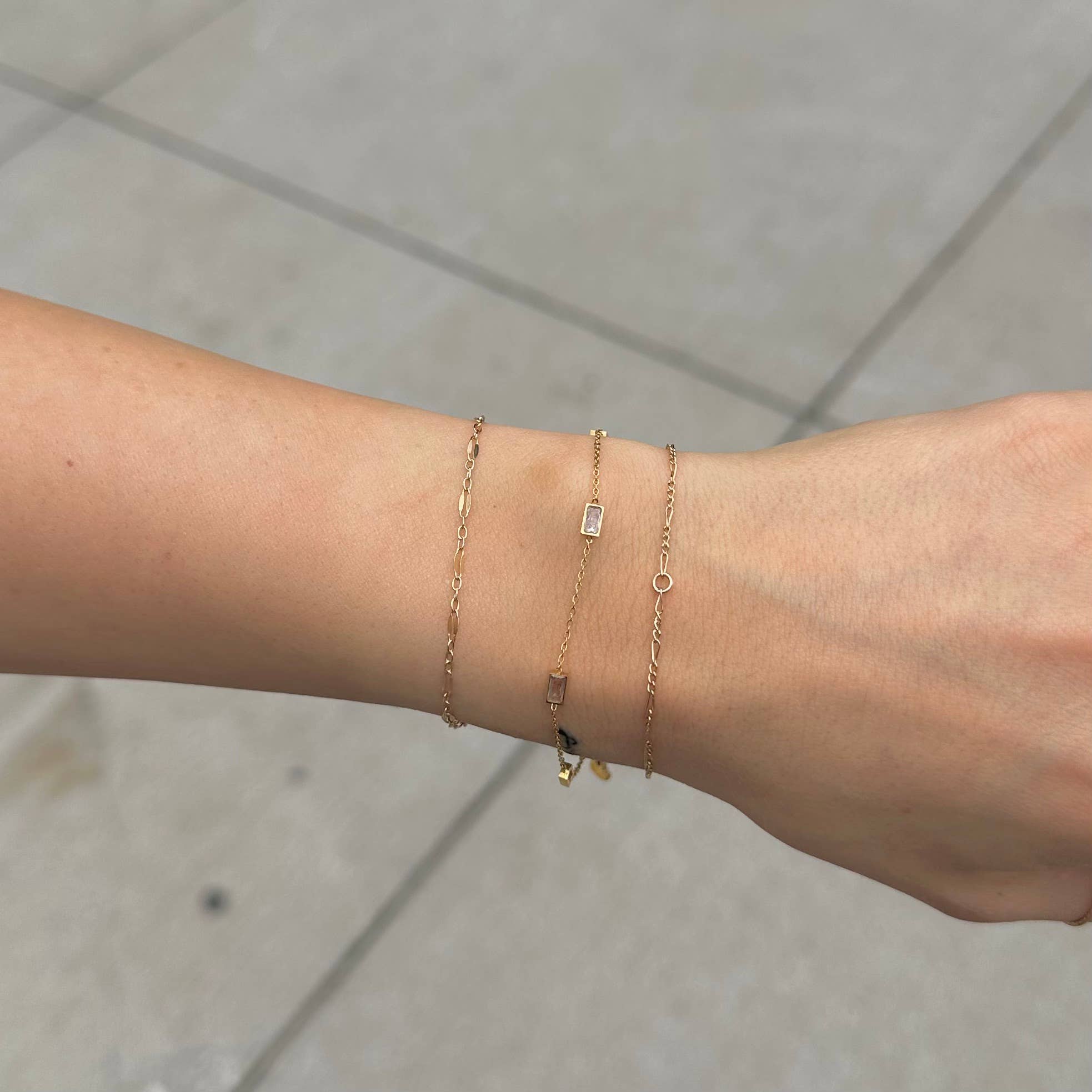 Woman wearing gold bracelet with three rectangle crystals 