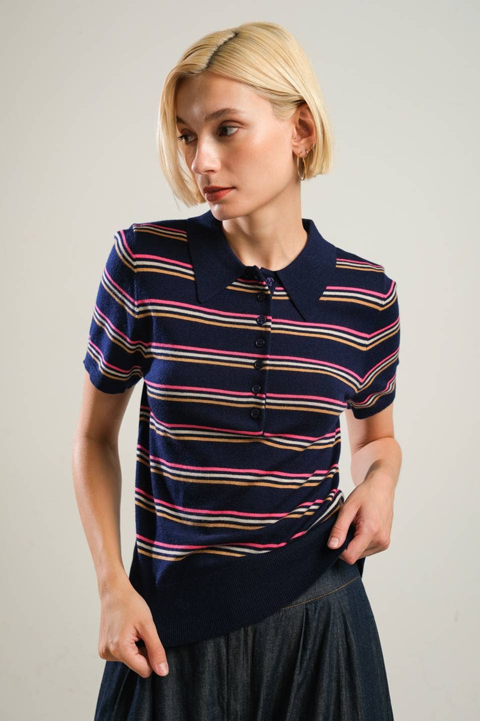 Woman wearing a striped polo shirt against a plain background