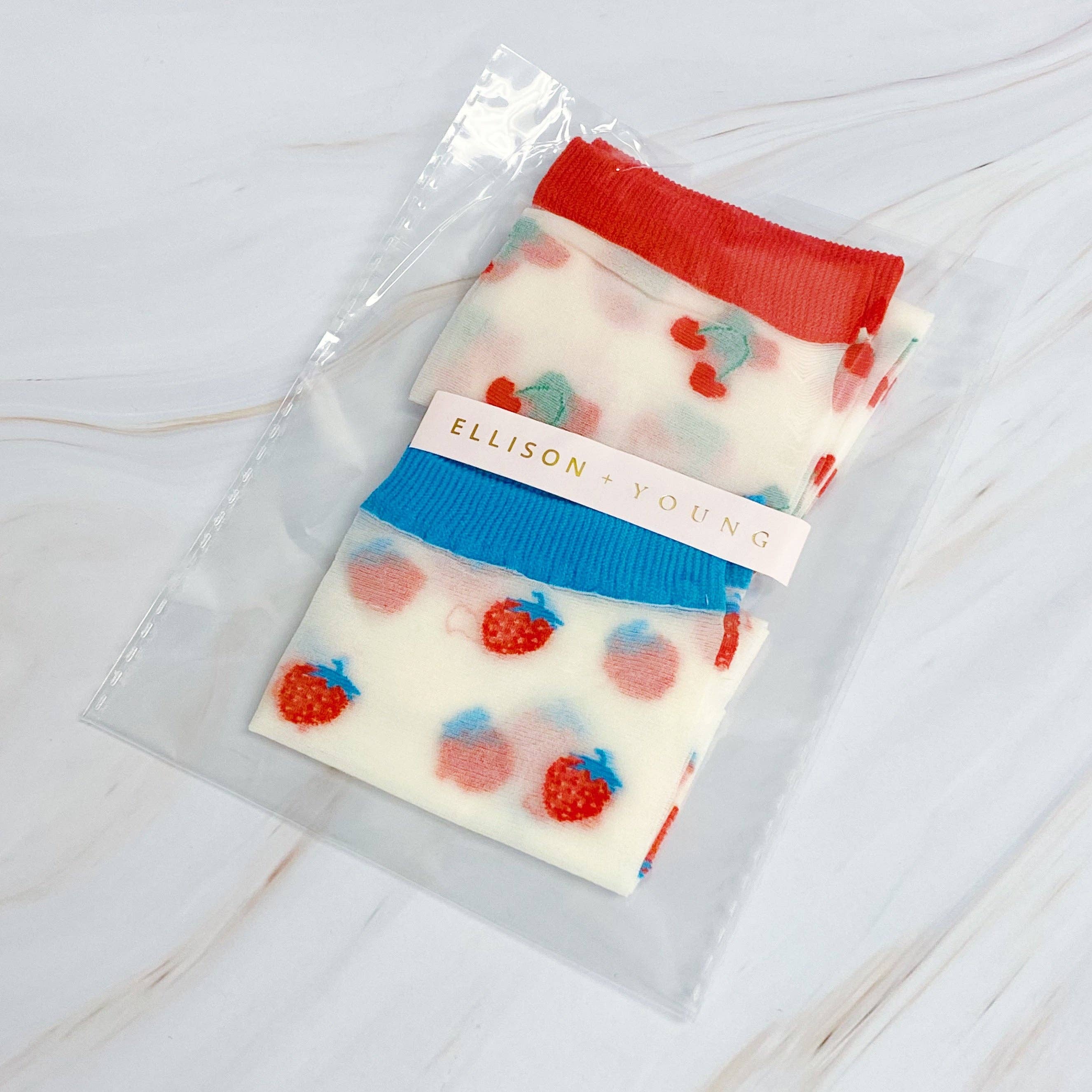 Packaged soap with strawberry design and 'Ellison Young' label on a light wooden surface