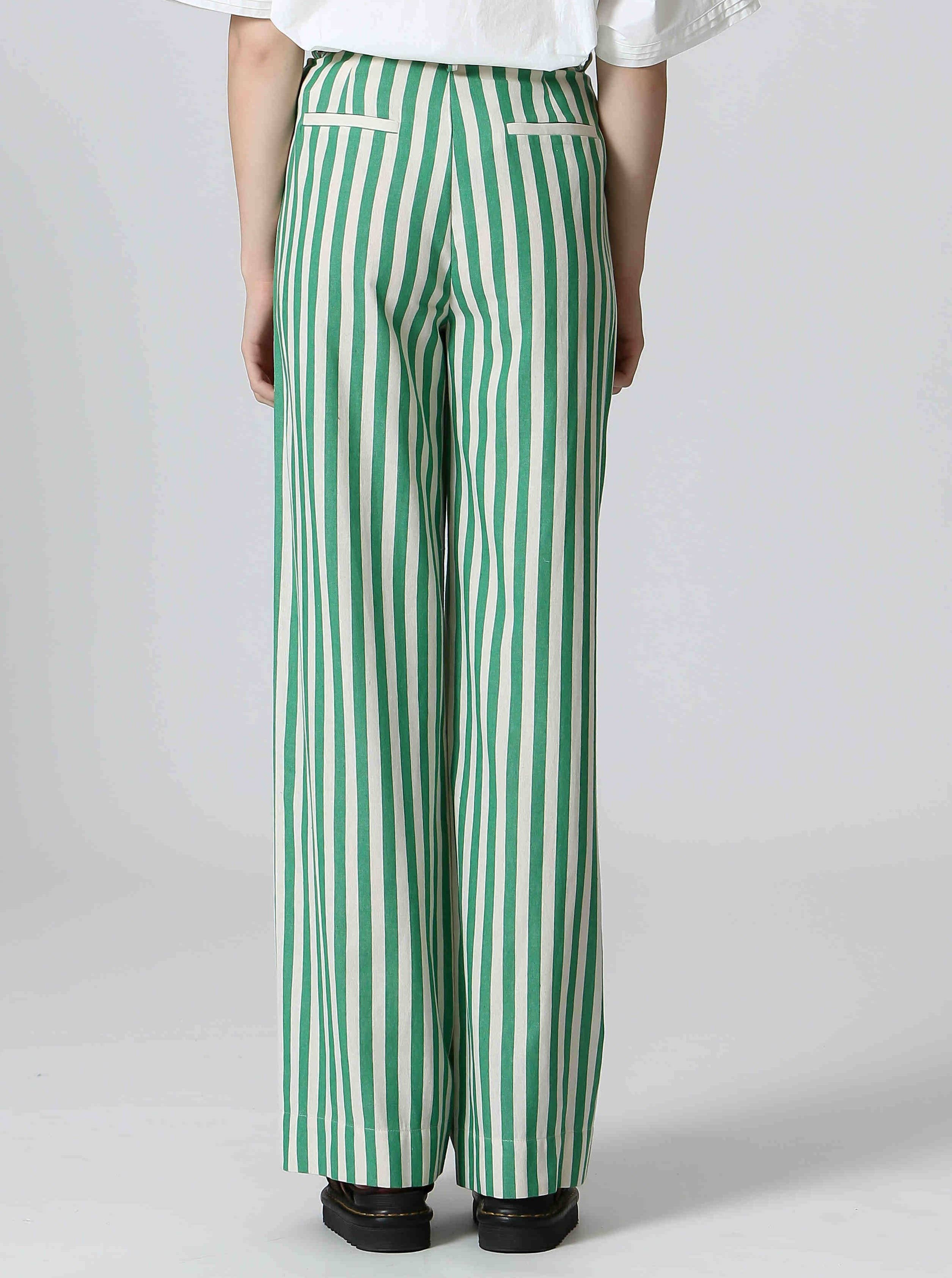 Woman wearing white shirt and green and white, vertically striped pants