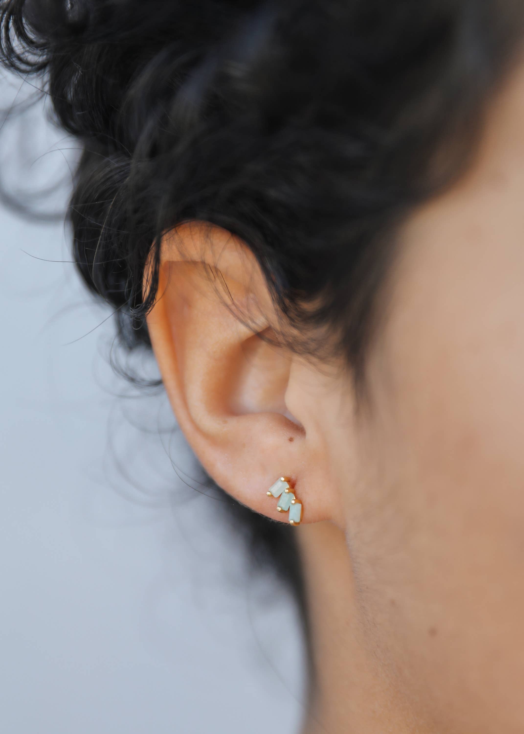 Close-up of an ear wearing a small earring with a blurred background