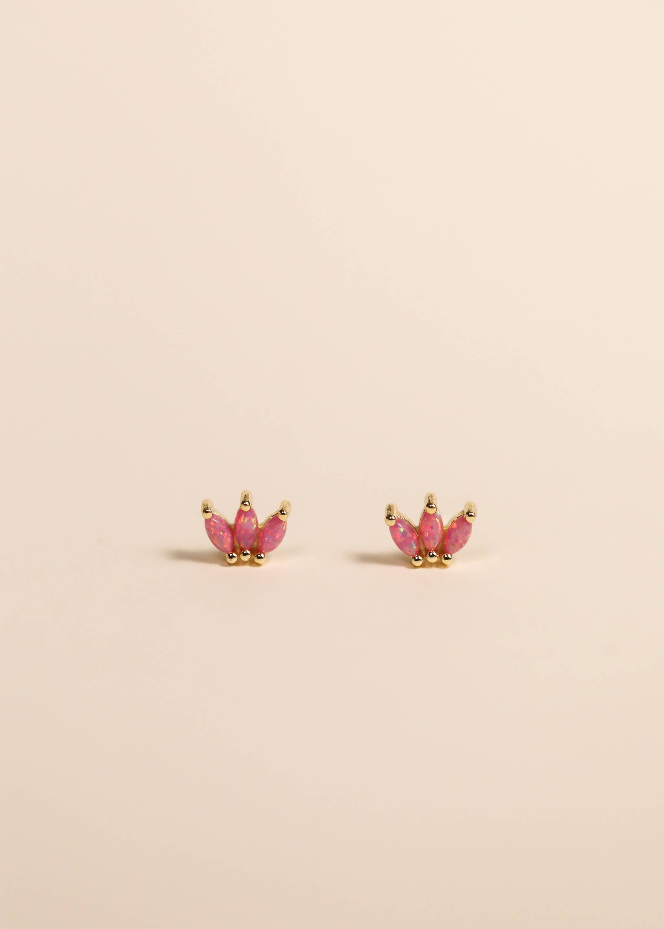 Pink Opal Stones set in a small crown set of gold with beige background 