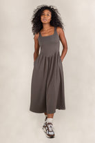 Woman wearing olive colored, midi dress, with corset bodice detail 