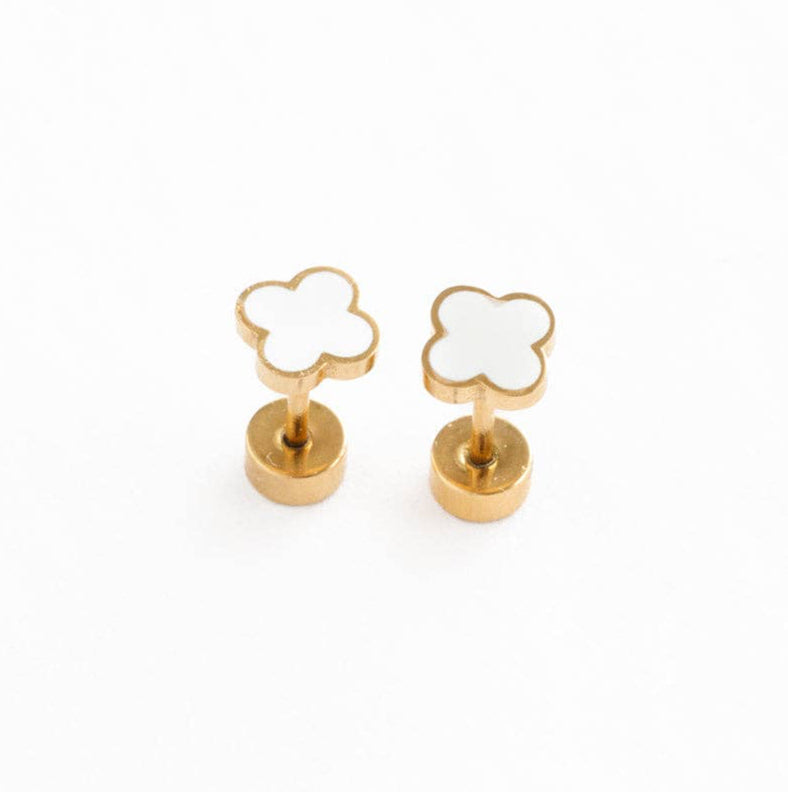 Pair of gold and white quatrefoil flat back earrings laying on a white surface