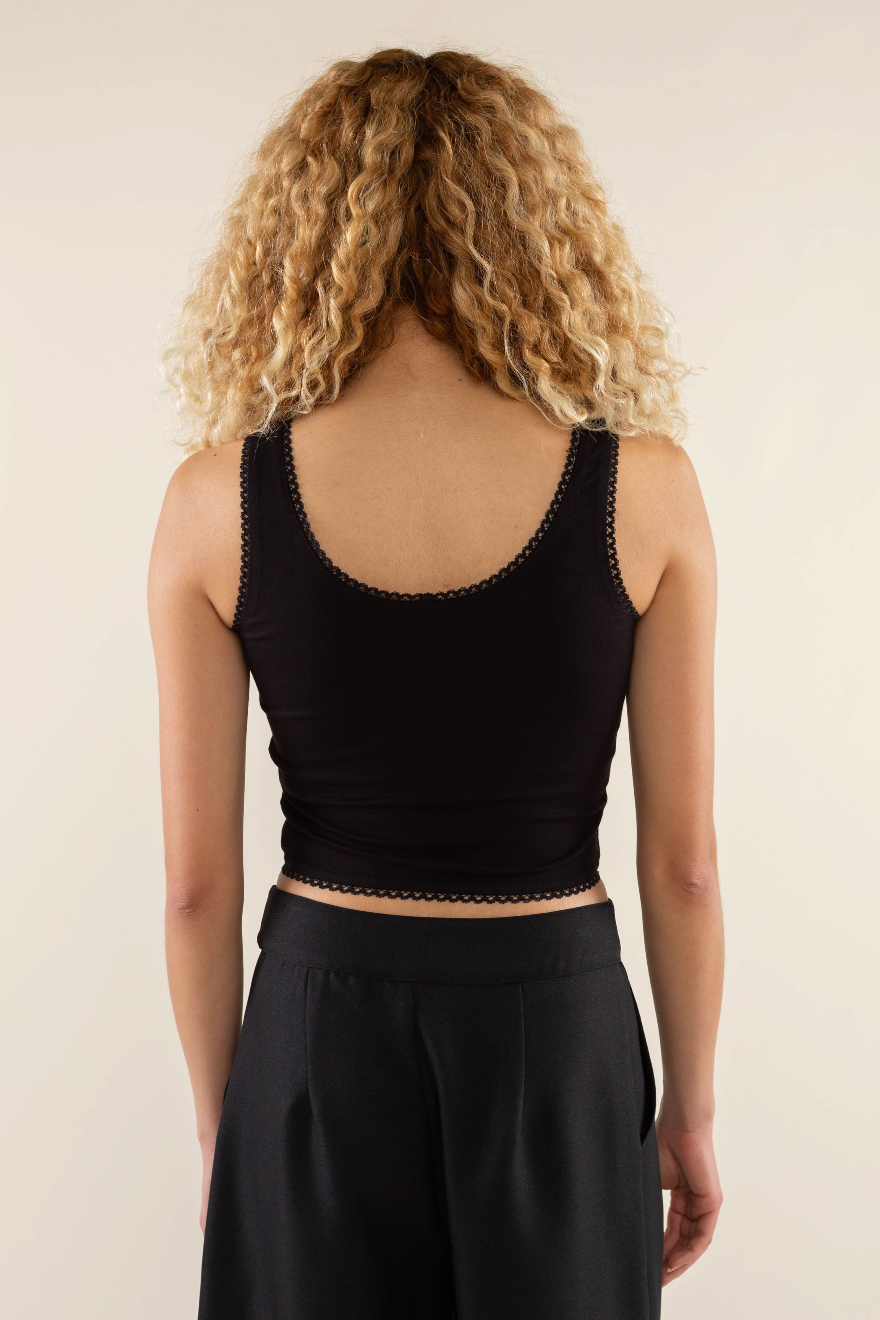 Woman wearing black, scallop trim, crop top with black jorts