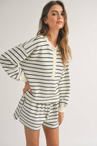 woman wearing black and white striped, half button cozy warm and stylish design