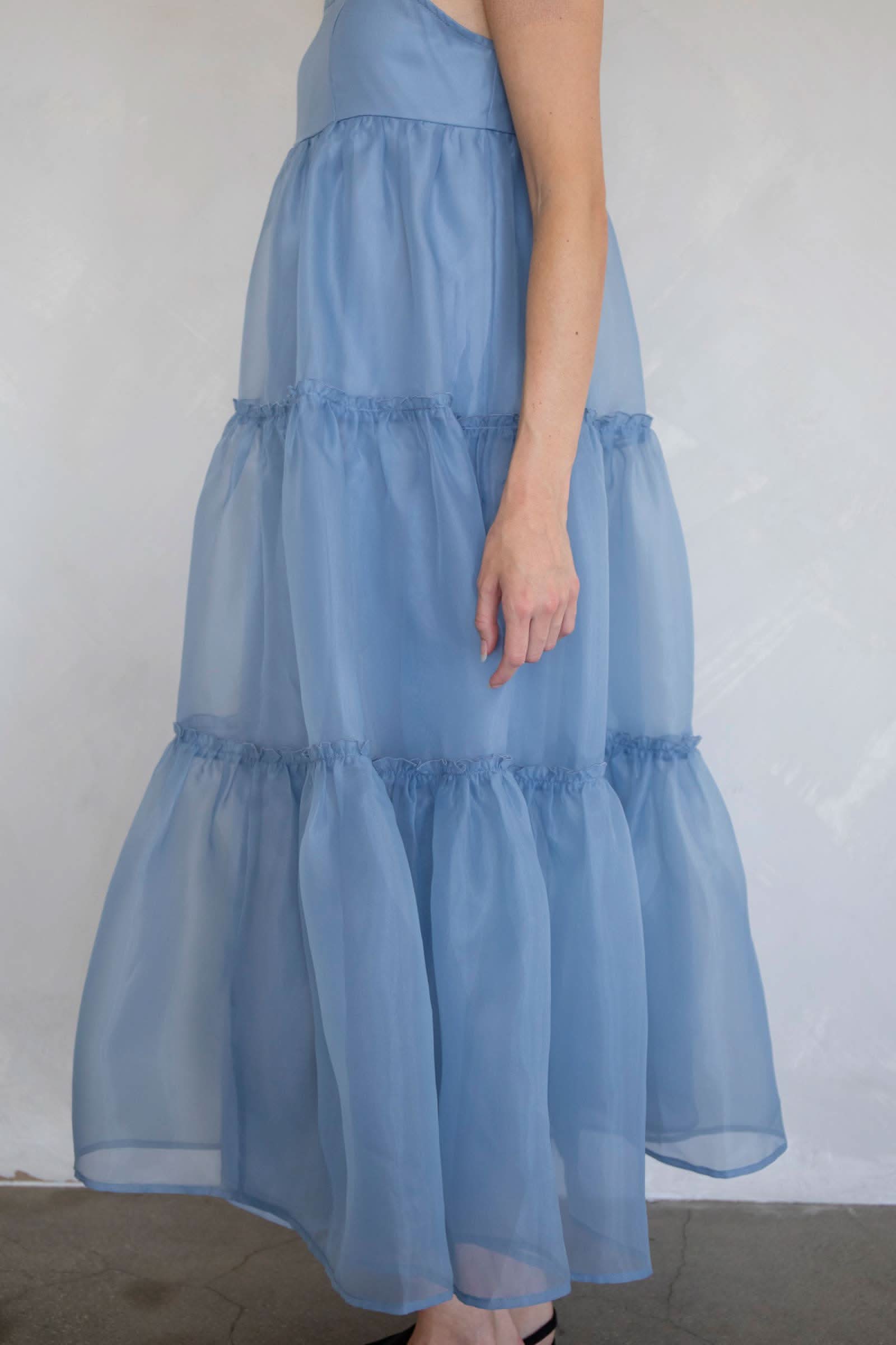 Light blue tiered dress worn by a person against a plain background
