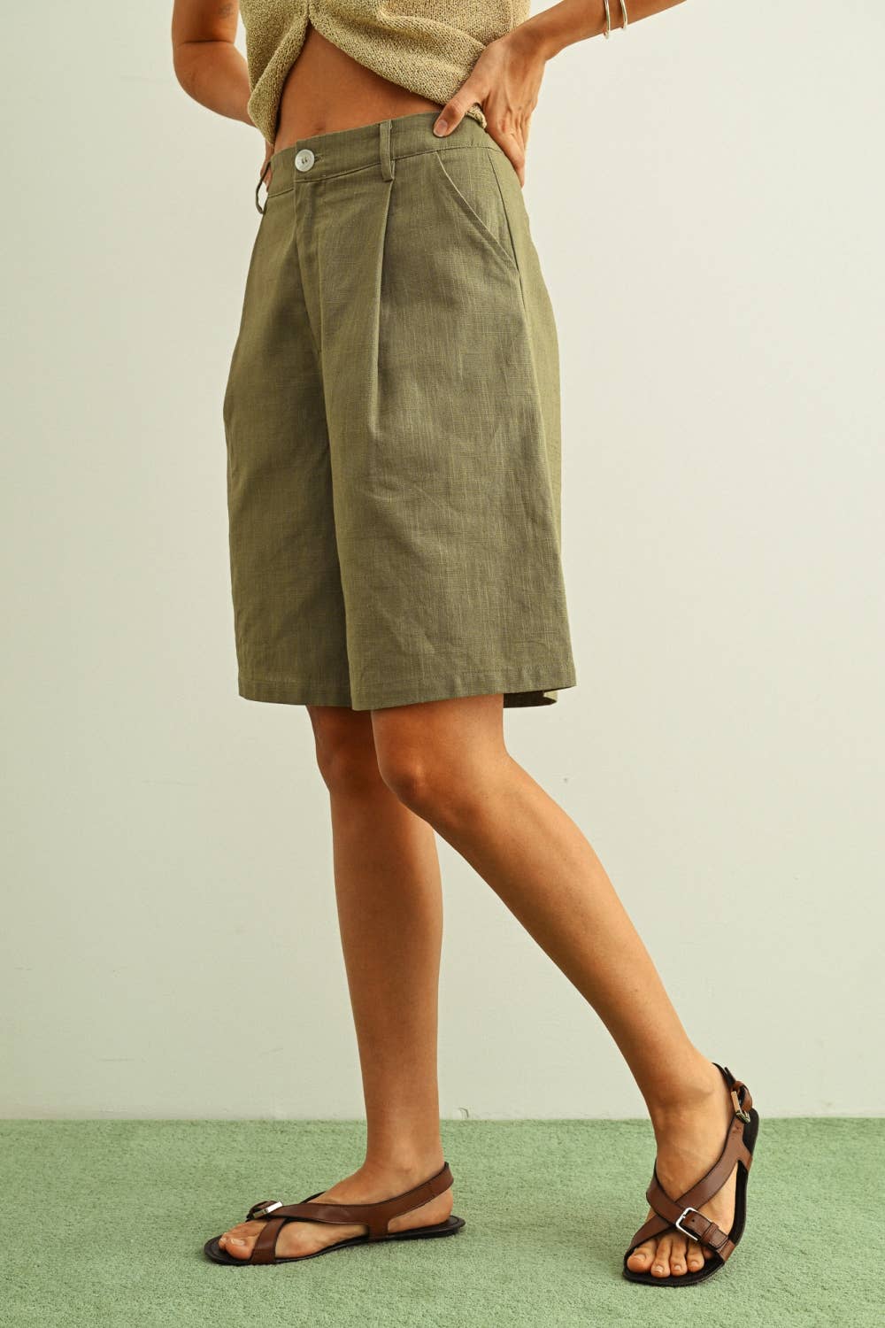 Person wearing green shorts on a plain background