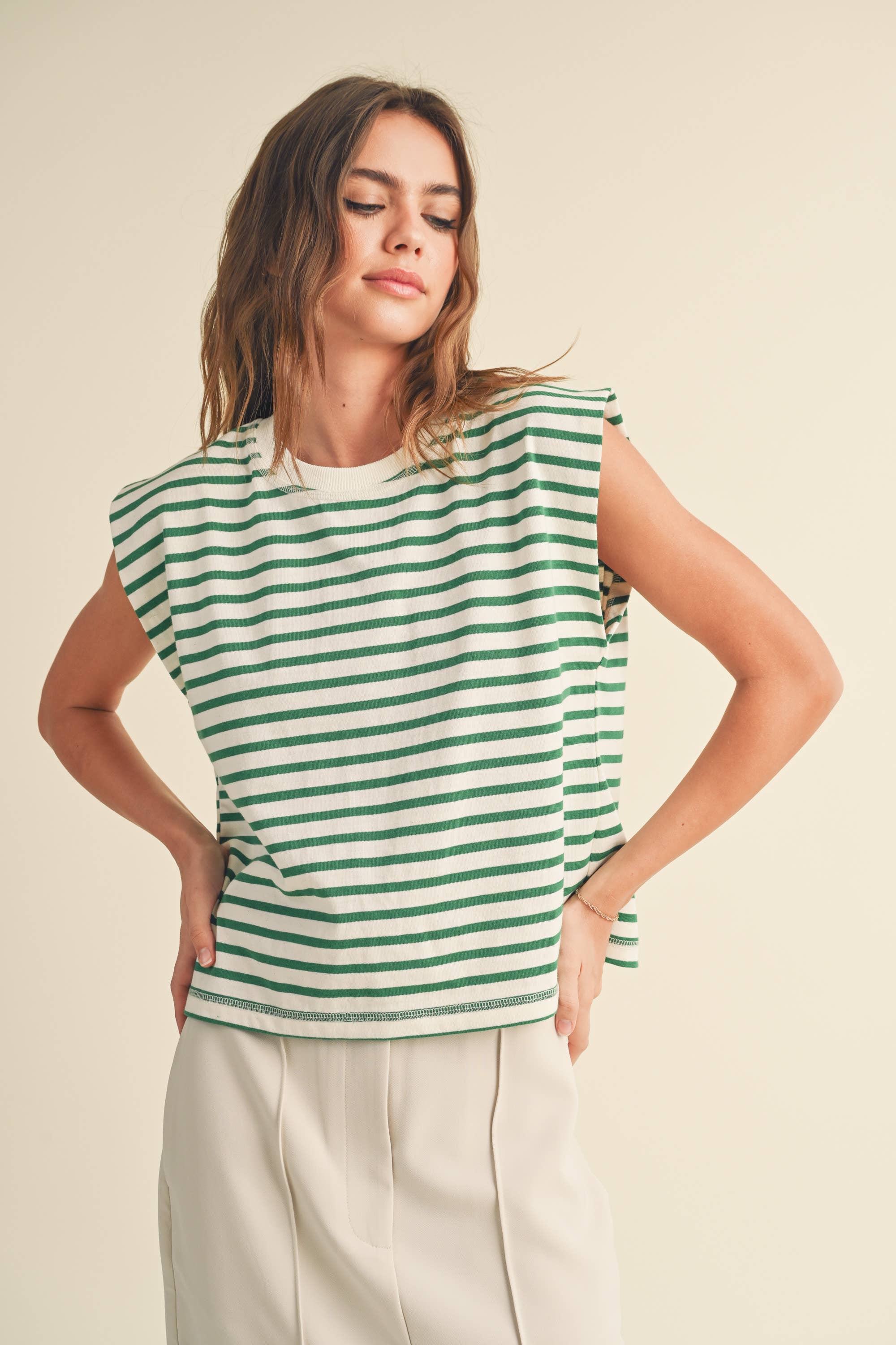 Woman wearing green and white striped cotton short sleeve top with a structured shoulders